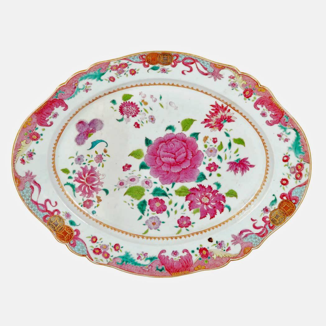 The large Chinesec Export shaped porcelain oval dish with a scalloped edge is finely painted with large European type flowers and bouquets in Famille Rose enamels.  The border painted with precious objects and finger citrus as well as stylized