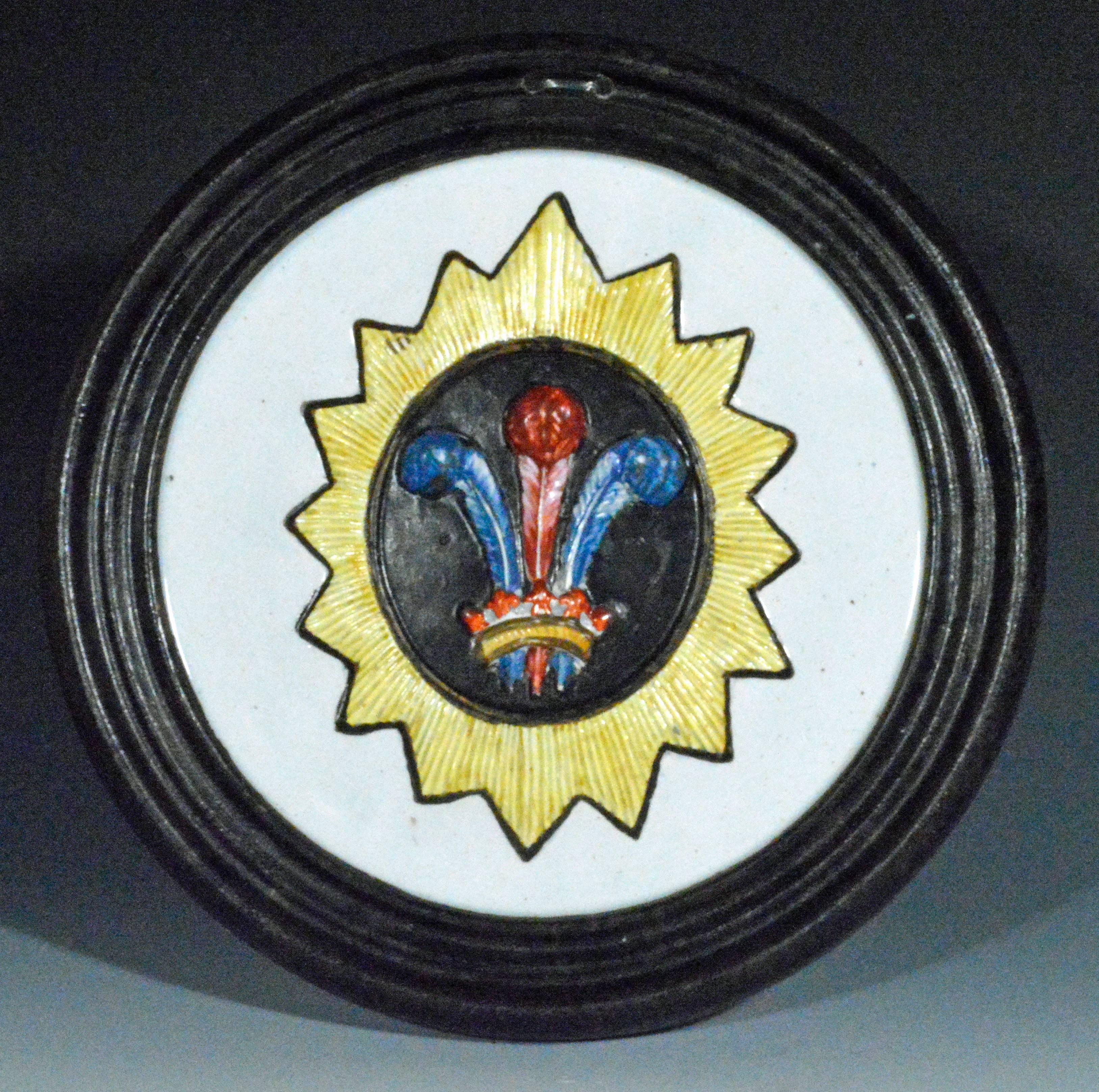 The large unusual Prattware circular plaques with a black outer border and a central molded panel are decorated with colored Prince of Wales feathers. These seem to be a unique pair being the only ones known.