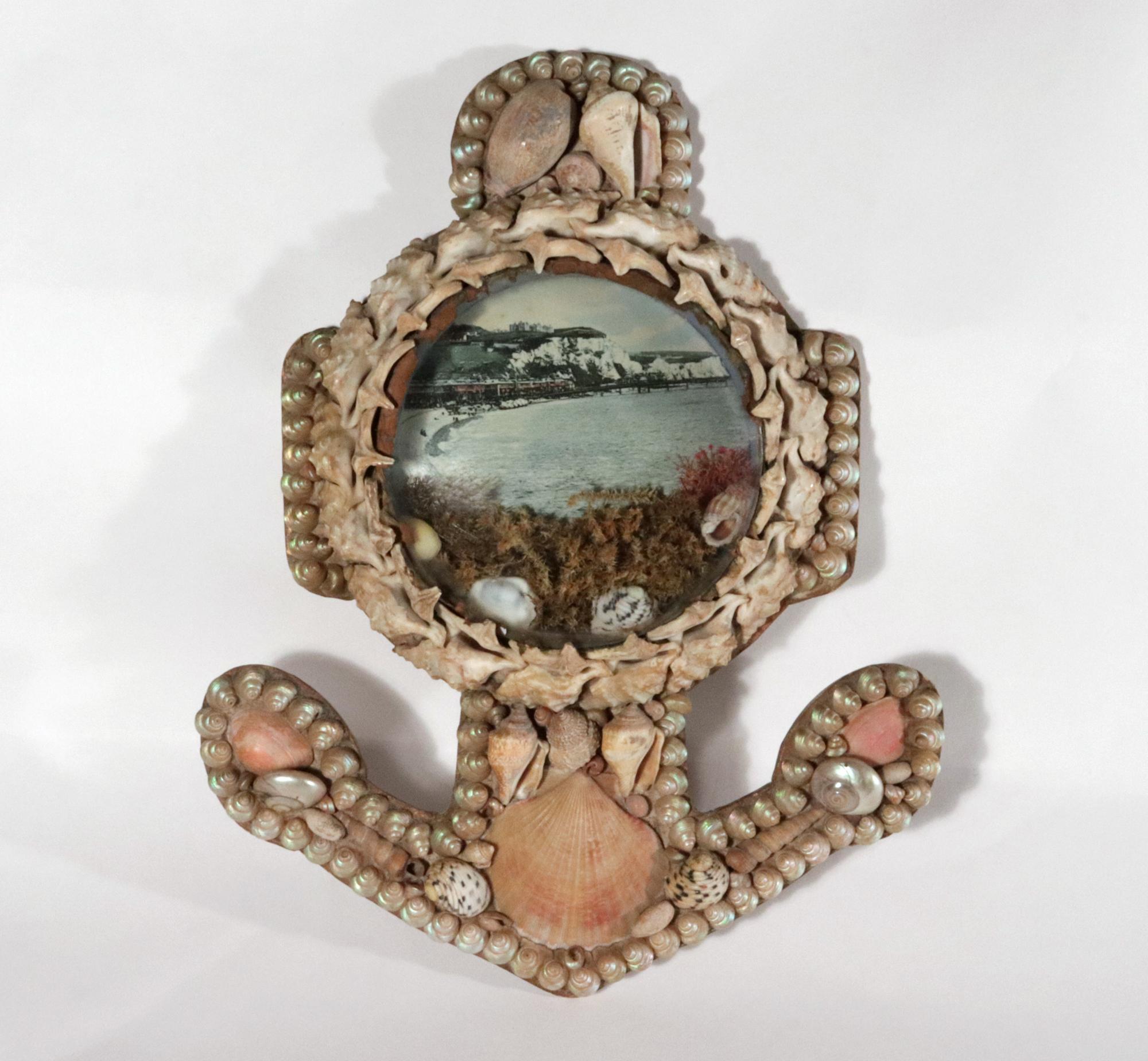 Edwardian Shellwork Valentine Diorama,
Dover with Pier,
1900

A large Edwardian shellwork diorama with bevelled glass and in the form of an anchor. The diorama features an early tinted print of the town of Dover with its pier on the beach and the