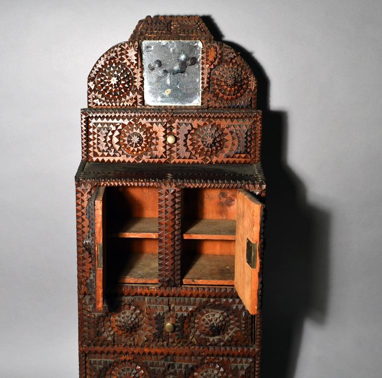 Folk Art American Tramp Art Cabinet,
A drawer marked Burlington, Vermont,
One-drawer signed MR.R,
early 20th century.

The charming and rare miniature cabinet with four drawers and a central storage space with two doors, each side of drawers with