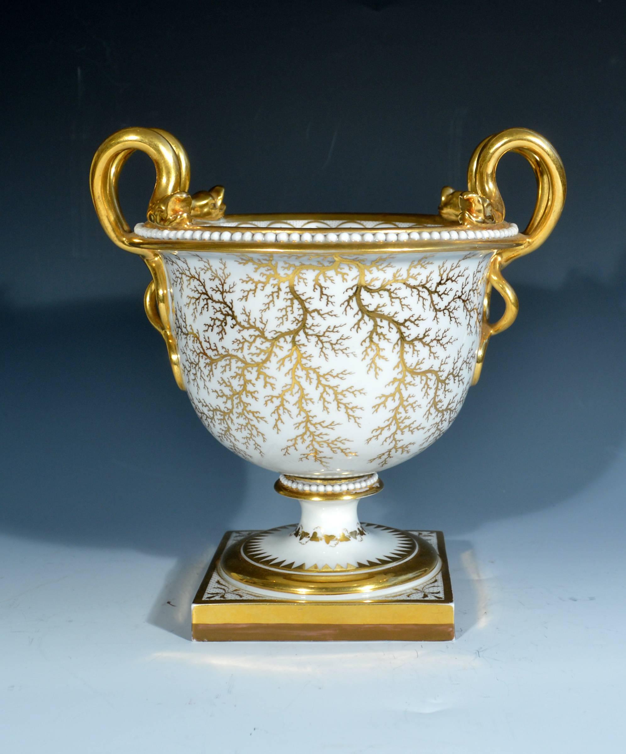 Flight, barr and barr porcelain urn, painted with Morpeth Castle, Northumberland.
circa 1815.

The flight, barr & barr porcelain urn has a vermilion ground with gilt intertwining snake handles, the urn raised on a square foot. The front of the