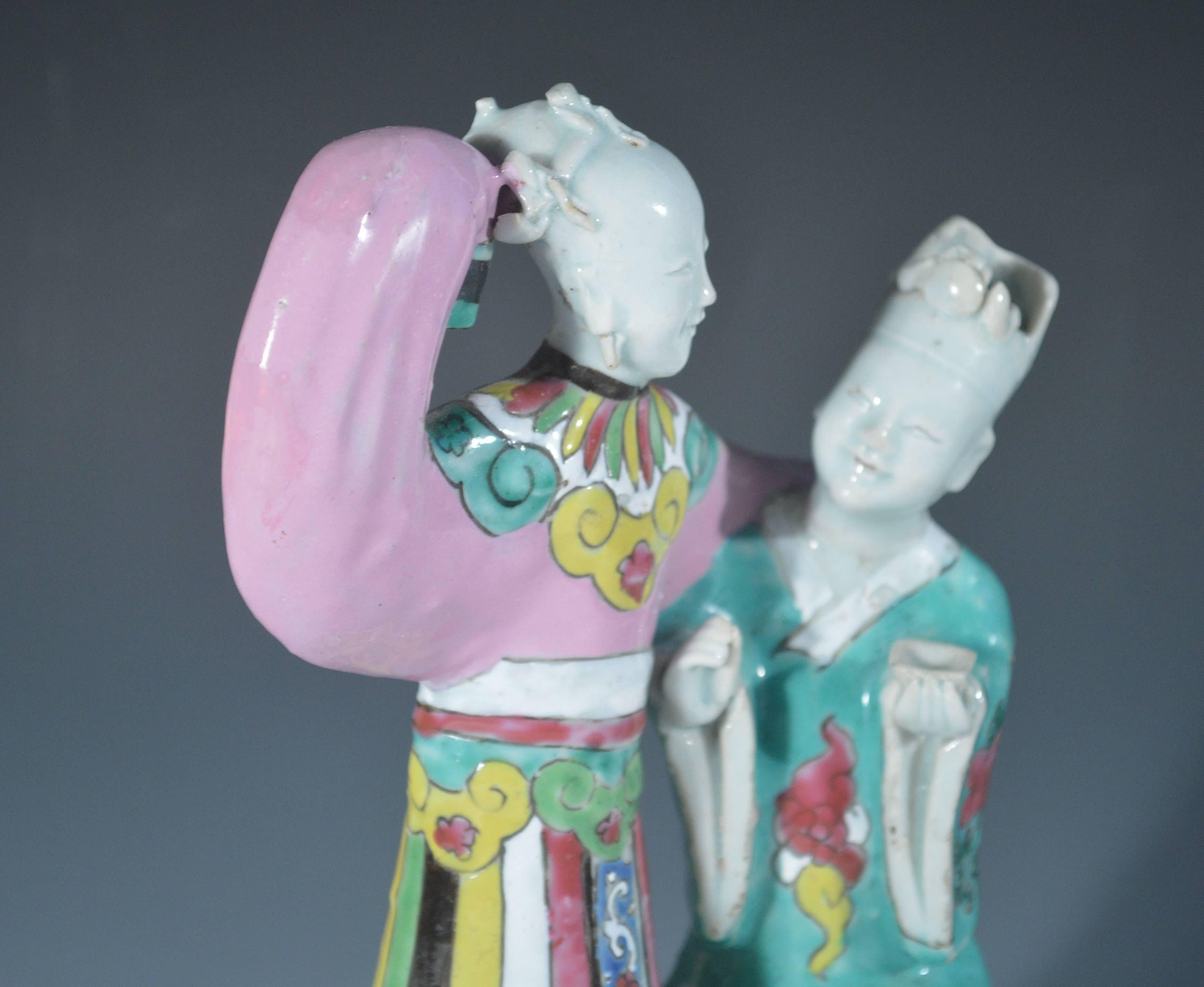 Chinese export porcelain figure group of two ladies,
late 18th century.

The unusual model depicts two figures. One, a lady in a multicolored striped garment, her right arm raised and another figure appearing to curtsey and holding a wine cup in