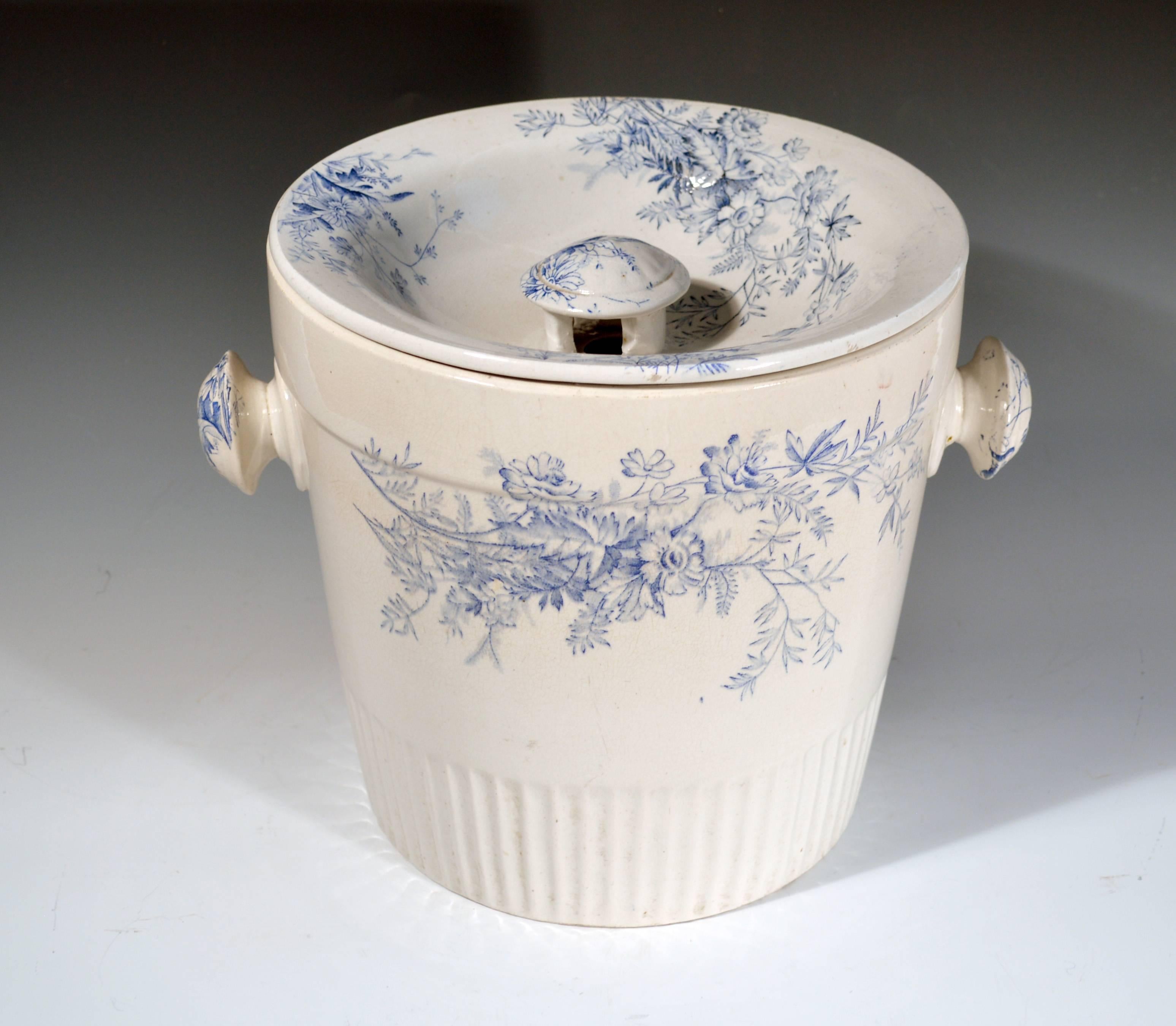 Blue and white floral pottery covered pil and cover,
Vera pottery,
circa 1900-1930.

The cylindrical pail with exterior knob handles has a reeded lower section and a printed blue and white design to each side, handles and cover. The cover with