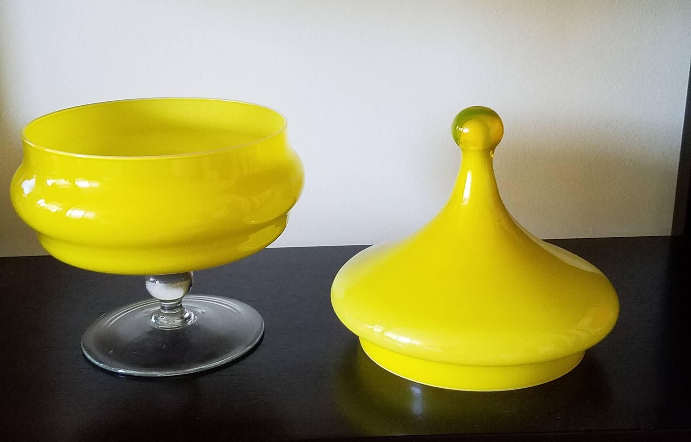 Vintage Italian Empoli Mid-Century glass yellow compote and cover.

The compote is in two parts with a cover with a nipple finial and a shaped circular base raised on a clear glass foot. The whole in cased yellow glass.


The town of Empoli is
