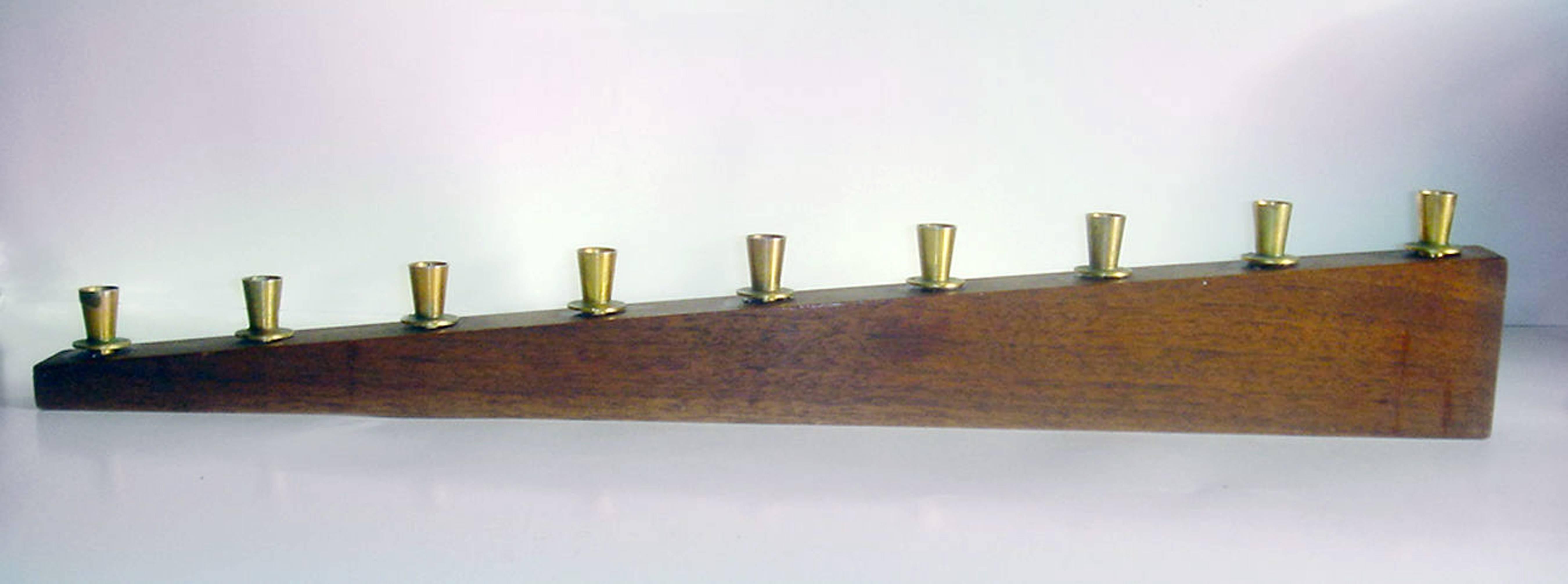 Paul Evans Hanukkah Menorah, 
For Raymor,
1955.

The menorah is made from walnut with brass candleholders. Paul Evan's menorahs were never marked.

The entry in the Raymor catalogue reads, 