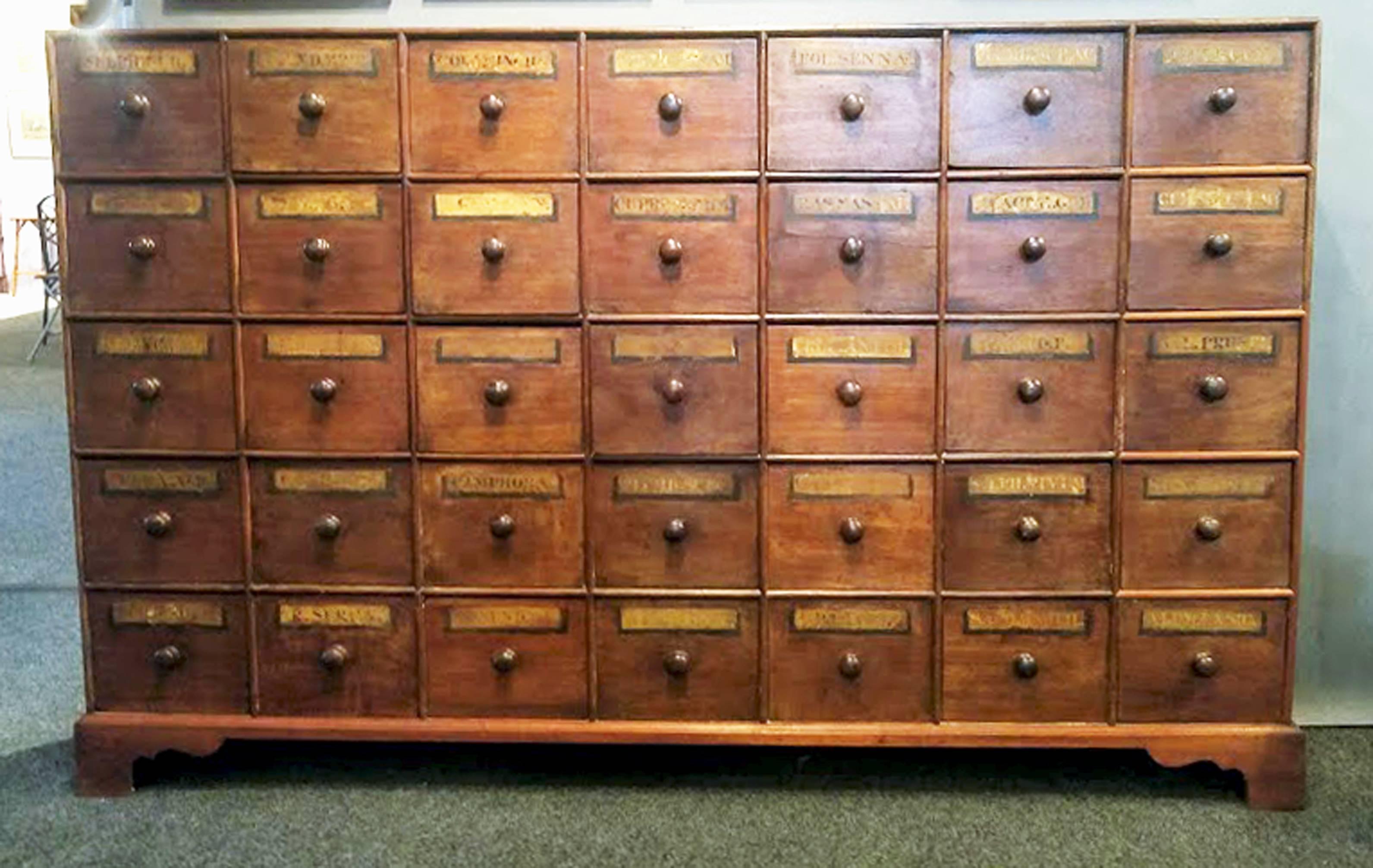 English large mahogany apothecary set of drawers,
19th century.

The mahogany apothecary set of drawers now on base has 35 different drawers in a seven across and five high arrangement. Each drawer with paper descriptions of contents now mostly