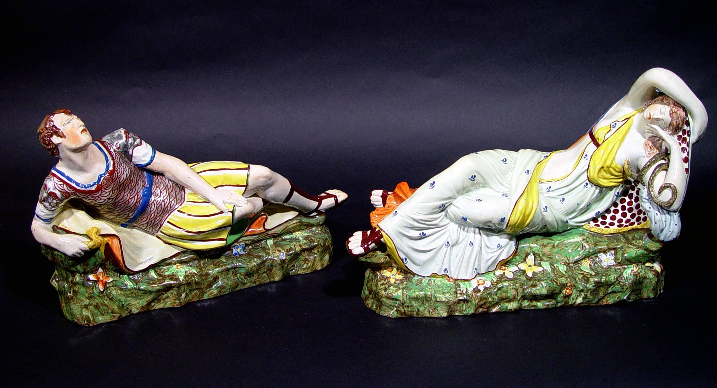 The pearlware figures are either by Enoch Wood or Enoch Wood and Caldwell. Each reclining on rocky ground angled to resemble a recamier, he wearing a cuirasse in platinum, she a yellow-lined gown painted with scattered purple flowers, a bright green