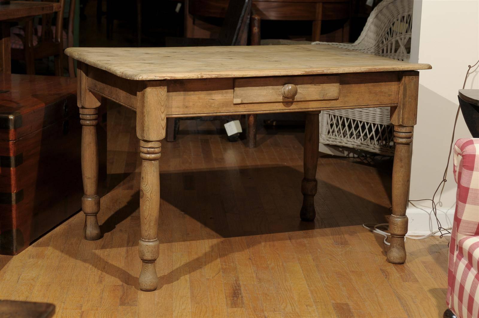 A nice pine table on turned legs that could be used as a work table, a desk or even a sofa table. It has one center drawer with a wooden knob.