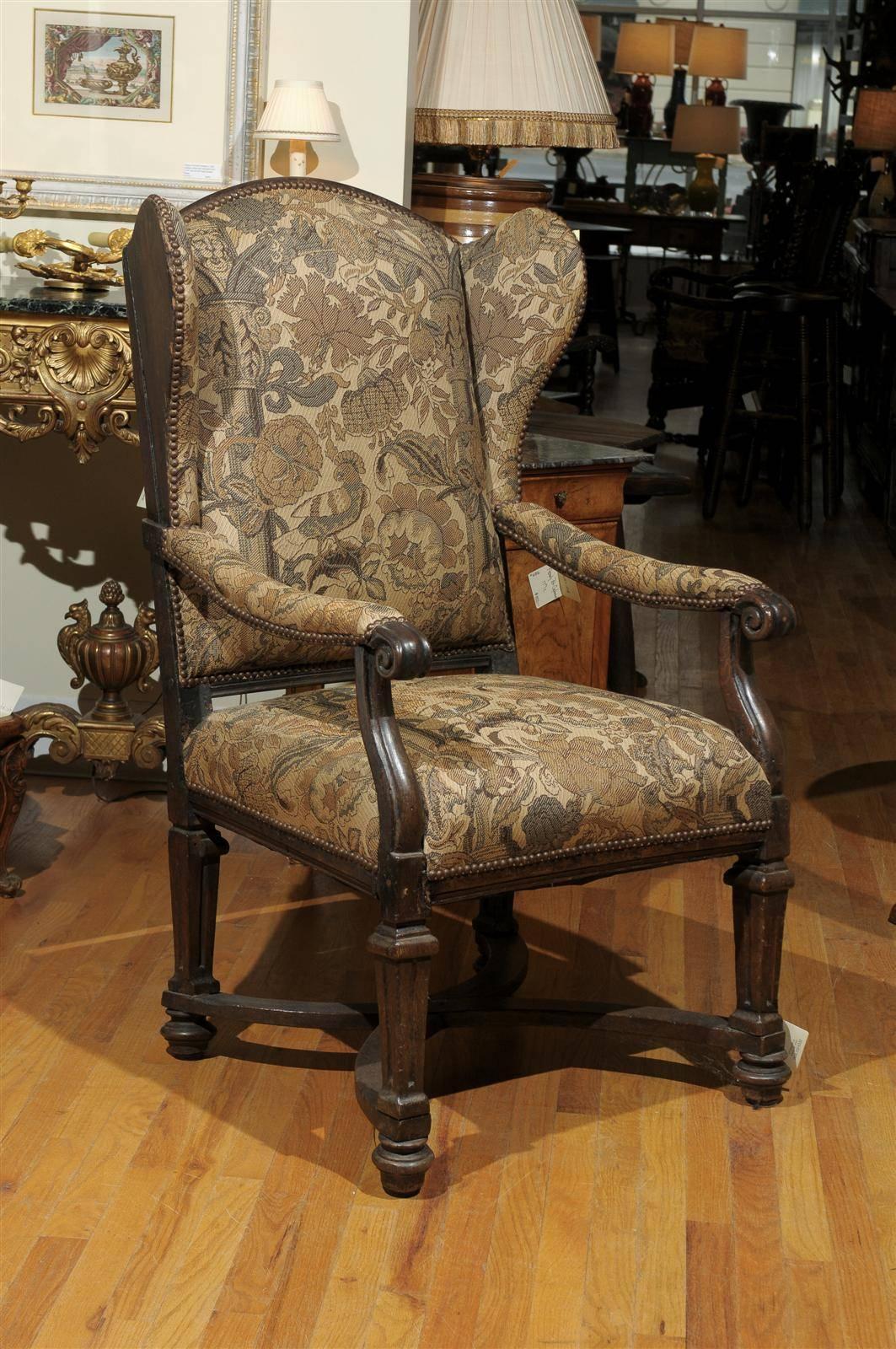 This is an 18th century wingback chair with new upholstery that reflects the time period. The wings on the back of the chair were meant to protect your face from drafts. They can be used in many rooms of your home and are very comfortable.