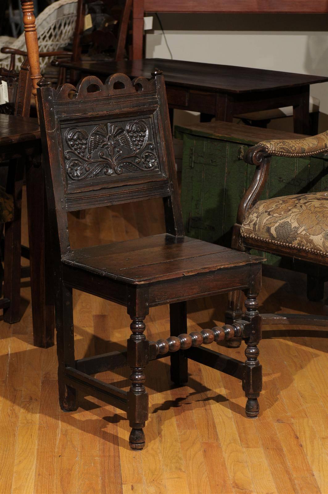 This is a beautifully carved 17th century oak chair. The back of the chair has a lovely carving of grapes and vines. This chair is Jacobean, which dates back to 1603-1625 when James I was king and up to 1688 during King James II reign. This type of