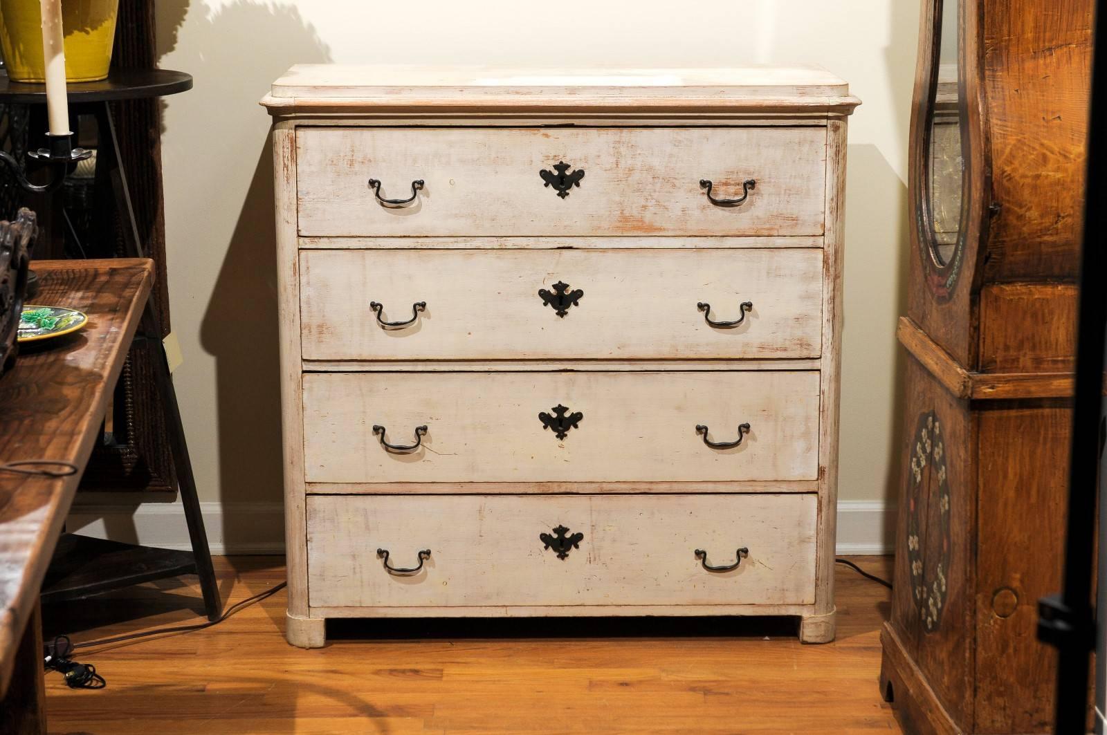 This English pine chest is finished in a light grey paint and has four drawers. The chest has classic swan neck pulls on each drawer.

