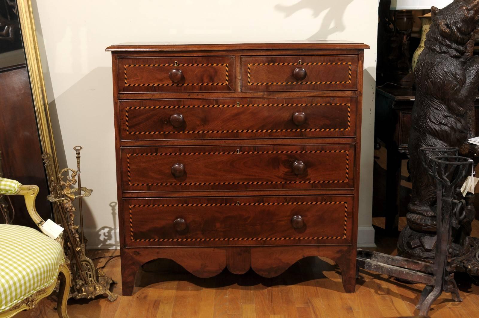 This beautiful, Classic English chest is made of mahogany. Each drawer on the chest has a patterned inlay with wooden knobs.