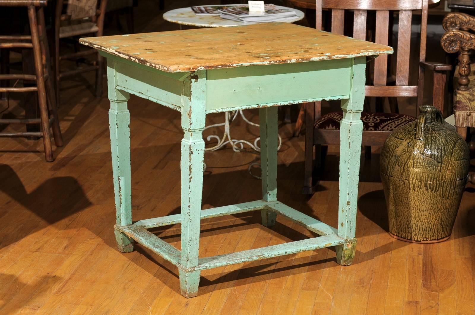 This lovely painted pine table is from Eastern Europe.  The top slides and it has great storage there,