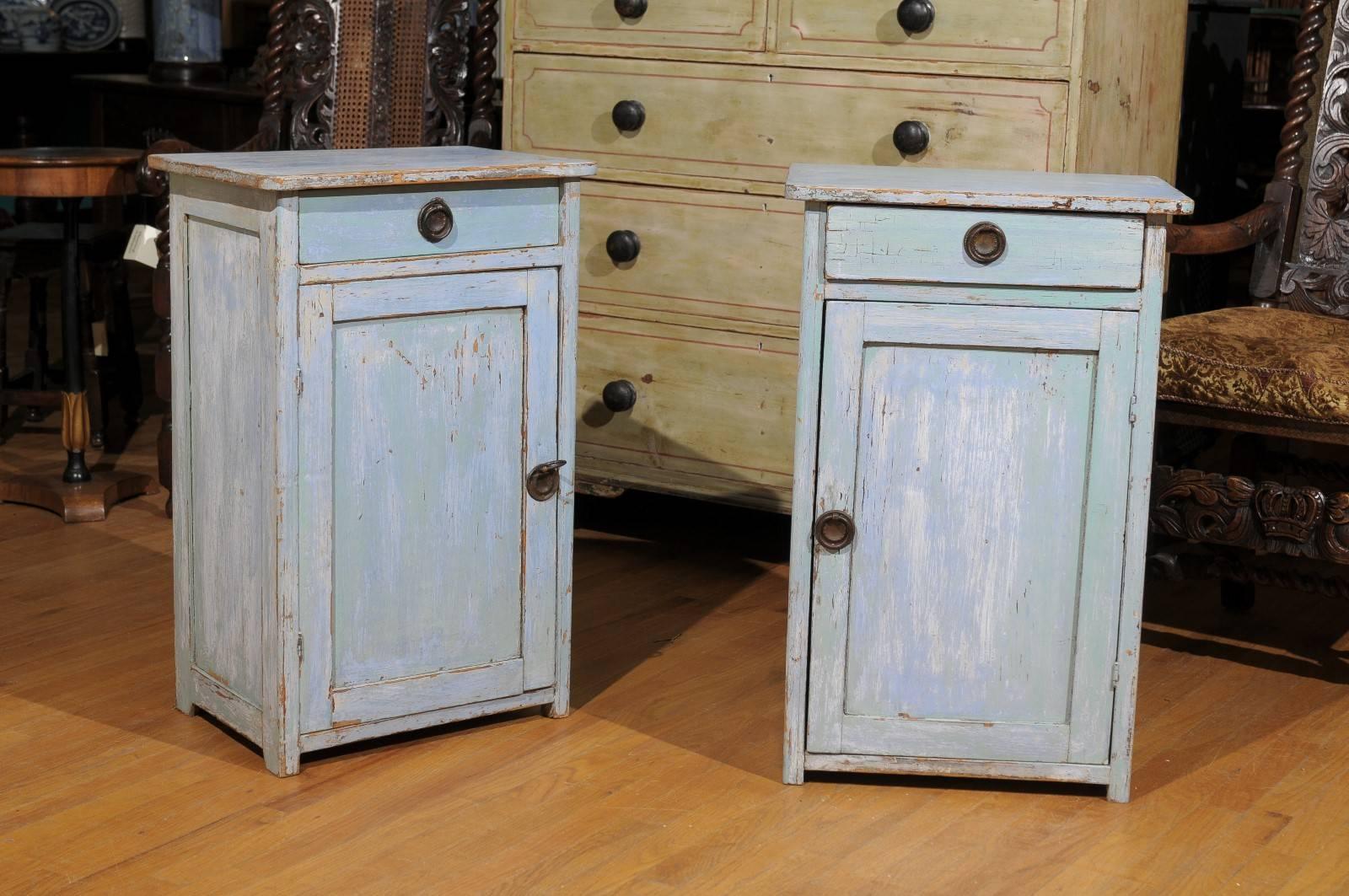 This is a pair of bedside cupboards with original paint. They have a small drawer at the top and a door that opens up to more storage. There is a shelf in the middle of the cupboard. These would work as beside tables, beside chairs for extra