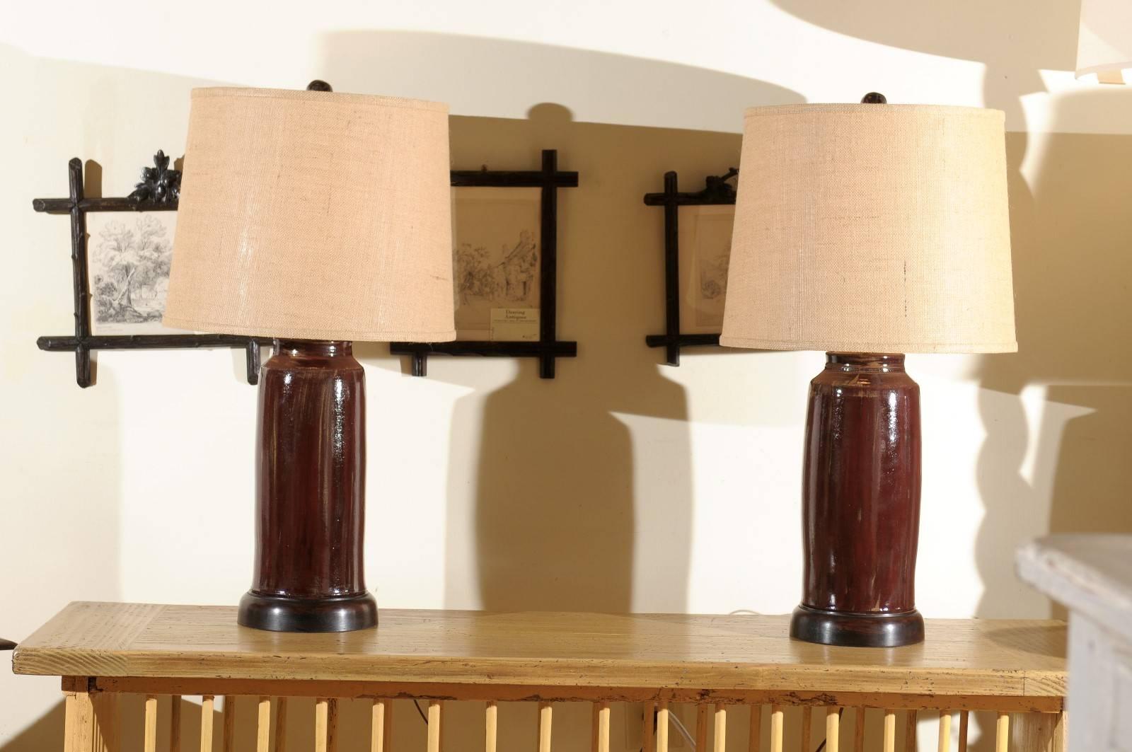 This is a pair of unique hand-turned lamps created by Charlie West, a noted North Georgia potter since 1986. They are mounted on a wooden base which is hand-turned on a wood lathe. All of his lamps are original.