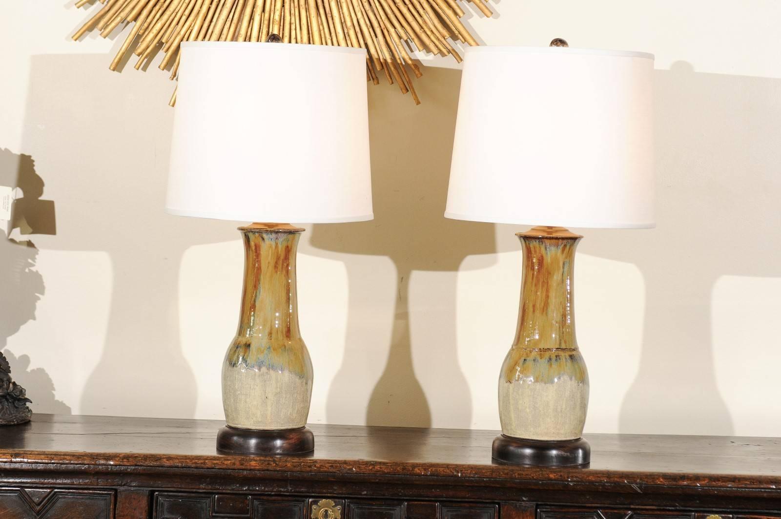 This unique pair of hand-thrown lamps created by Charlie West, a noted North Georgia potter since 1986. They are mounted on a wooden base which is hand-turned on a wood lathe. Each of his lamps is an original. We can order a single or a pair.