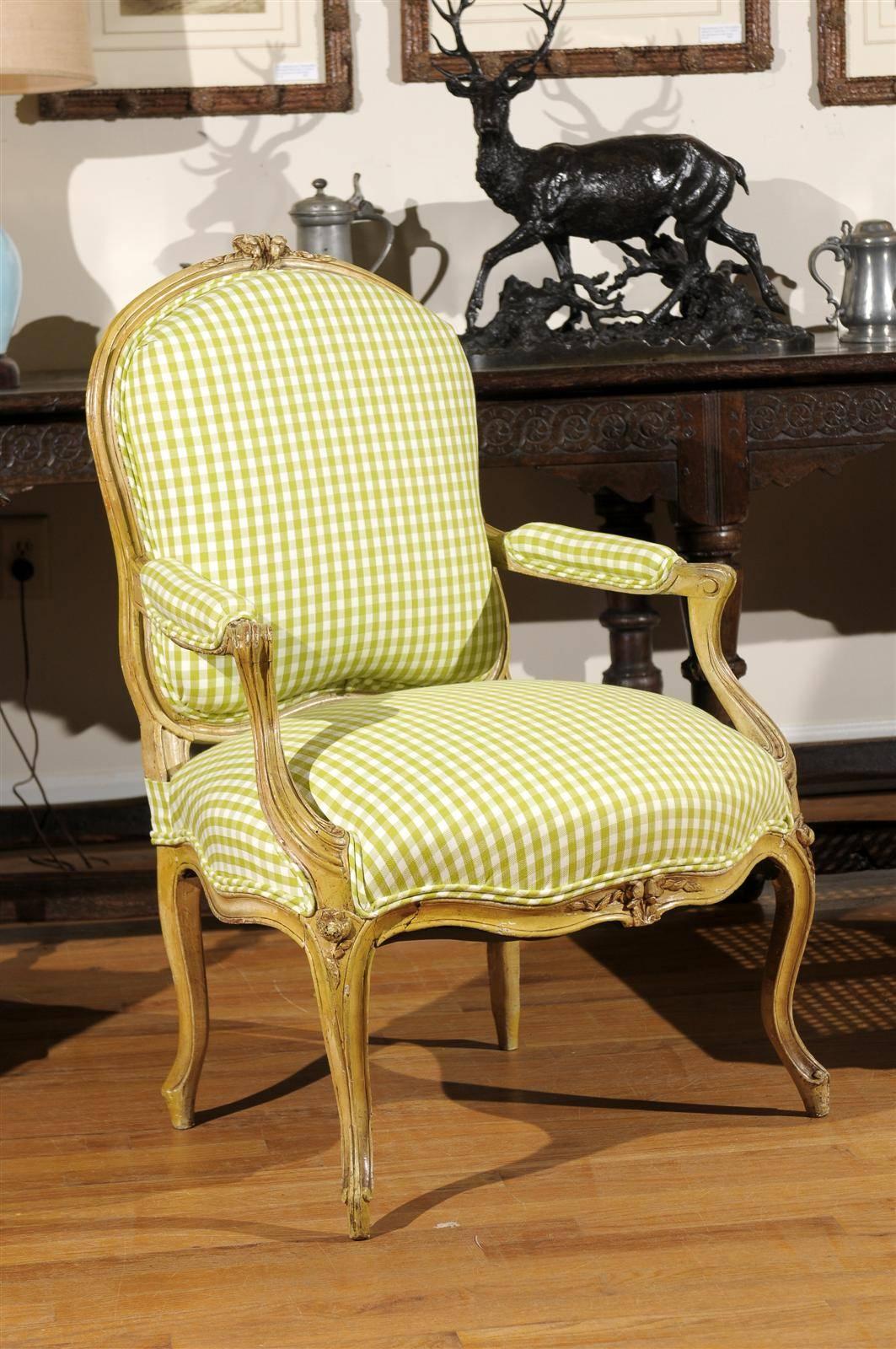 This is a newly upholstered French bergere armchair with padded armrests from the 1880s-1900s. The legs and arms are hand-carved with lovely flower embellishments.