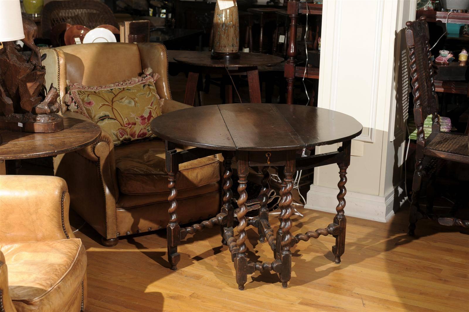 The table is made of dark oak with beautiful barley twist legs. There is a lovely patina to this piece. When the leaves are dropped the table is only 11.5" wide. Each leaf drops 14" which allows for a total of over almost 40" if