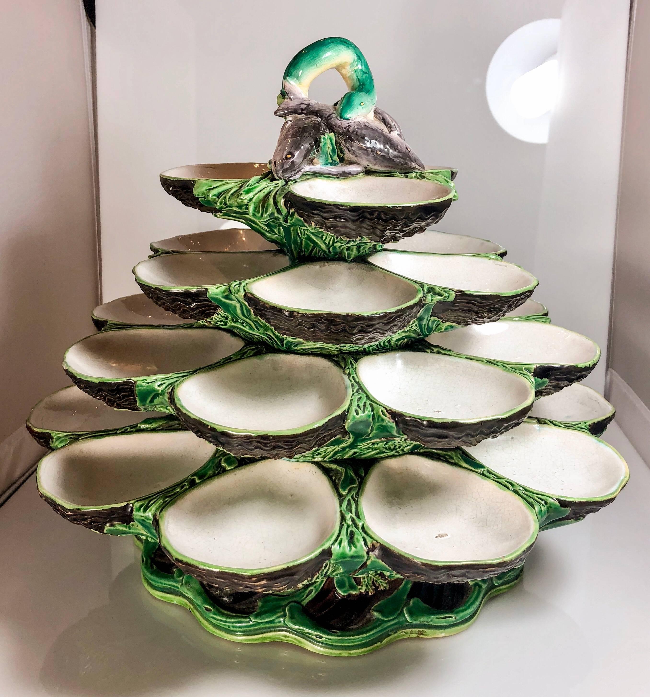 Revolving four-tiered oyster server signed Minton Company, circa 1875. Featuring a vibrant green glaze and sculpted animal and natural details.