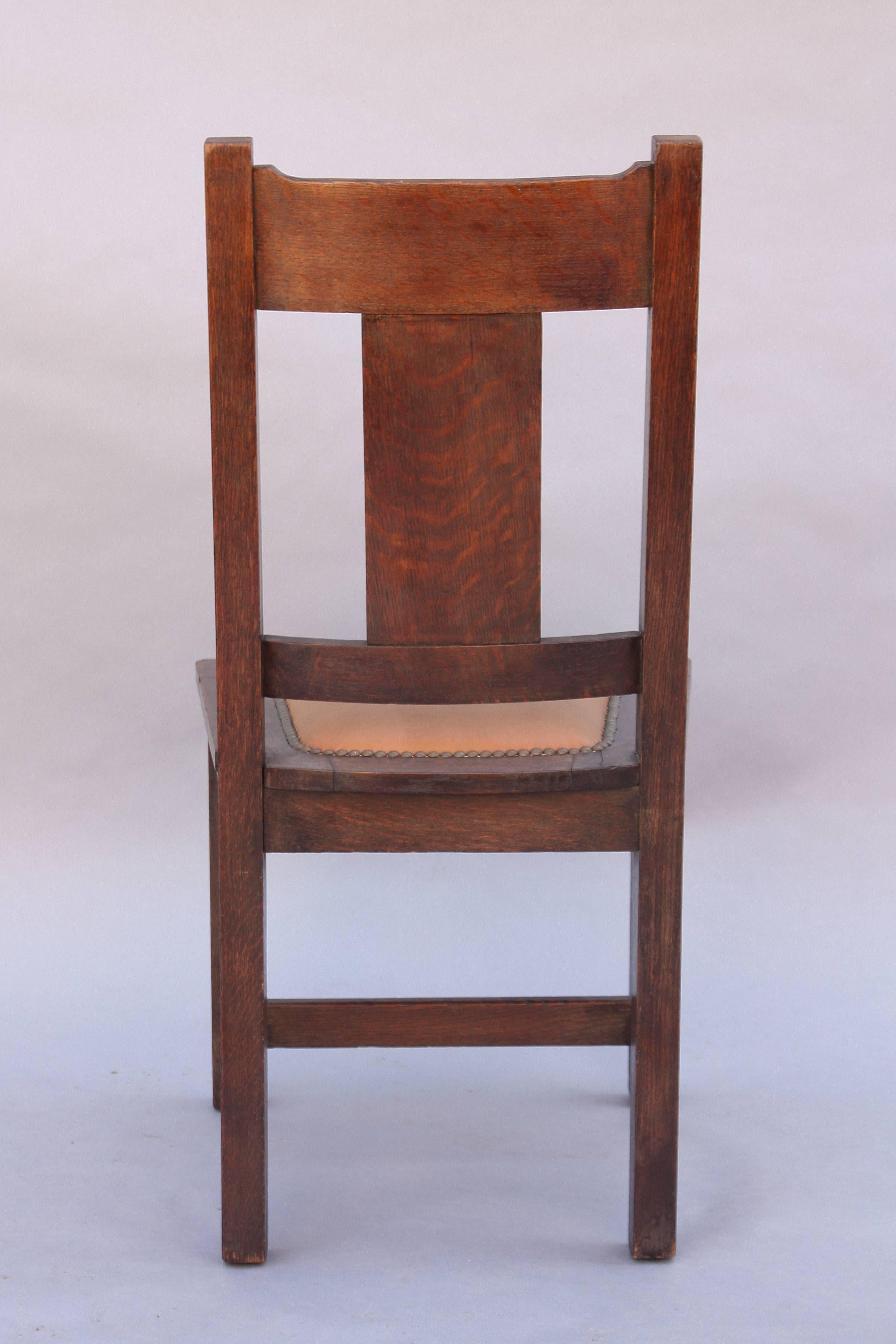 Oak side chair with riveted leather upholstery, circa 1910.
