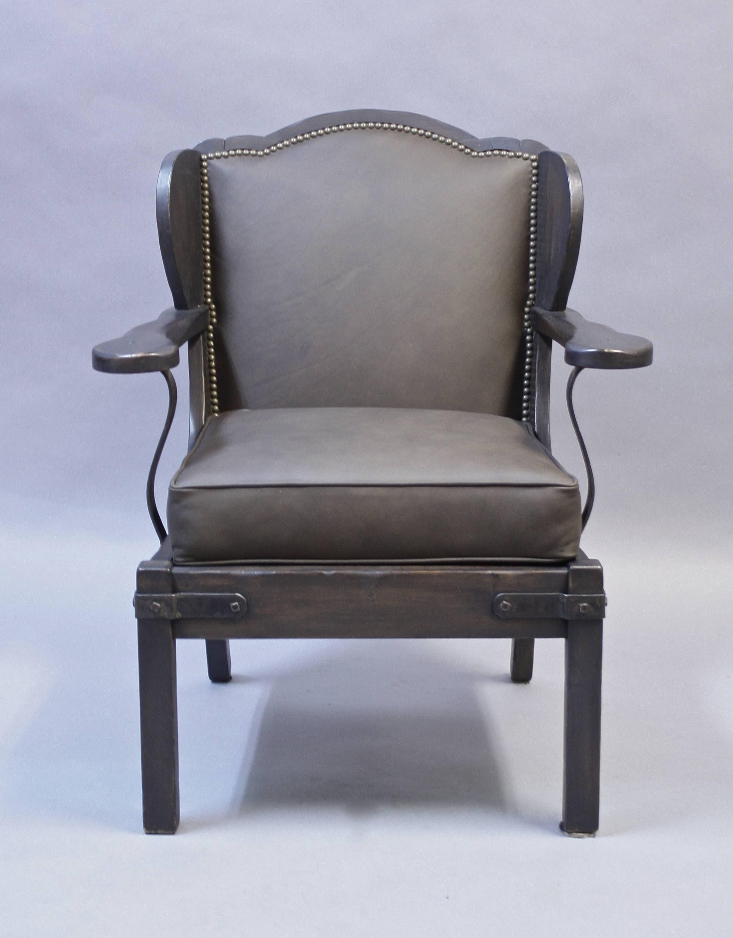 Handsome armchair with new leather upholstery and restored finish. Iron strapping. Measures: 35" H x 29.5" W x 29.25" D x 20" seat height.