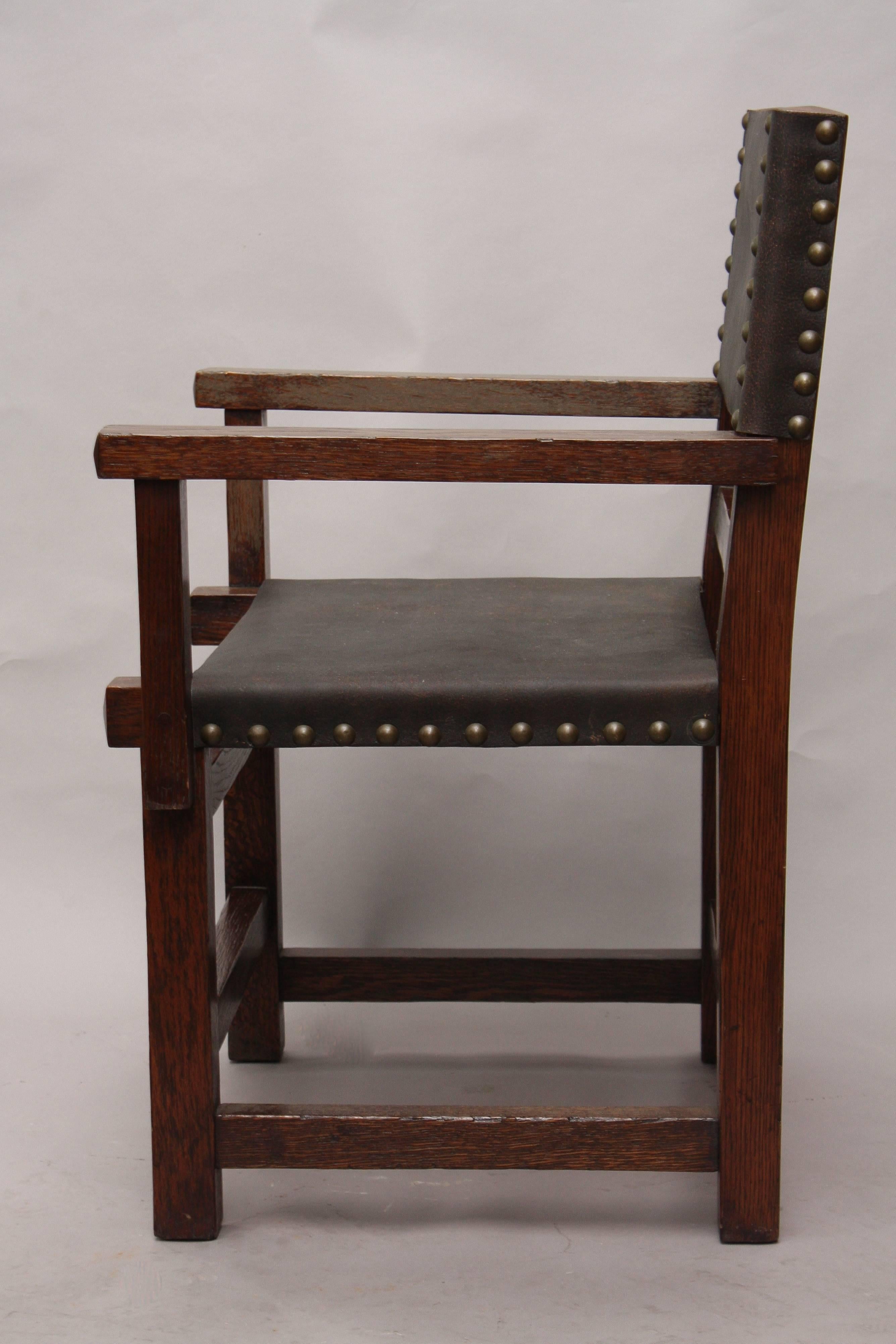Arts & Crafts period oak chair with new leather upholstery.