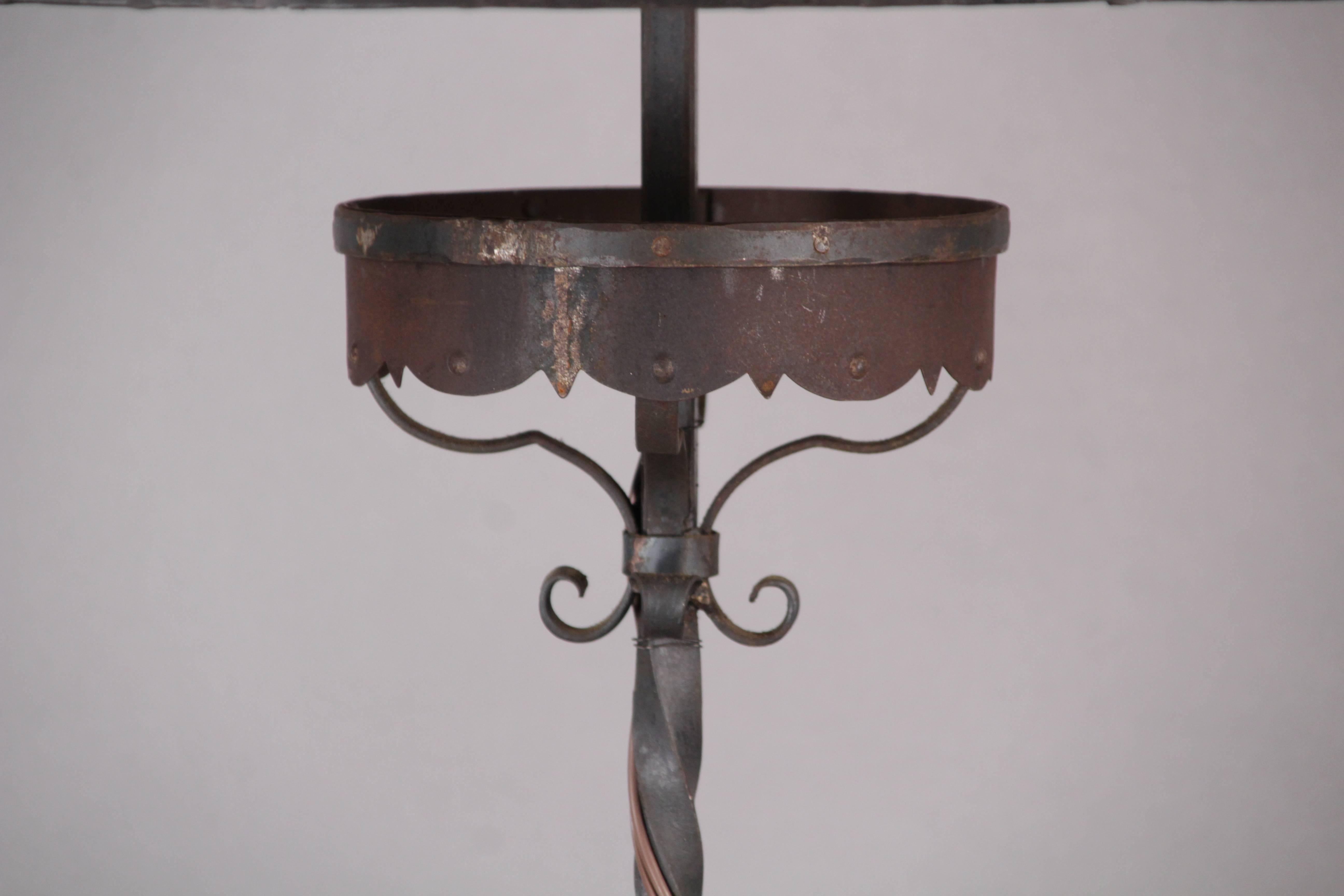 Tall wrought iron floor lamp with wrought iron riveted mica shade, circa 1920s. Great tall wrought iron base.