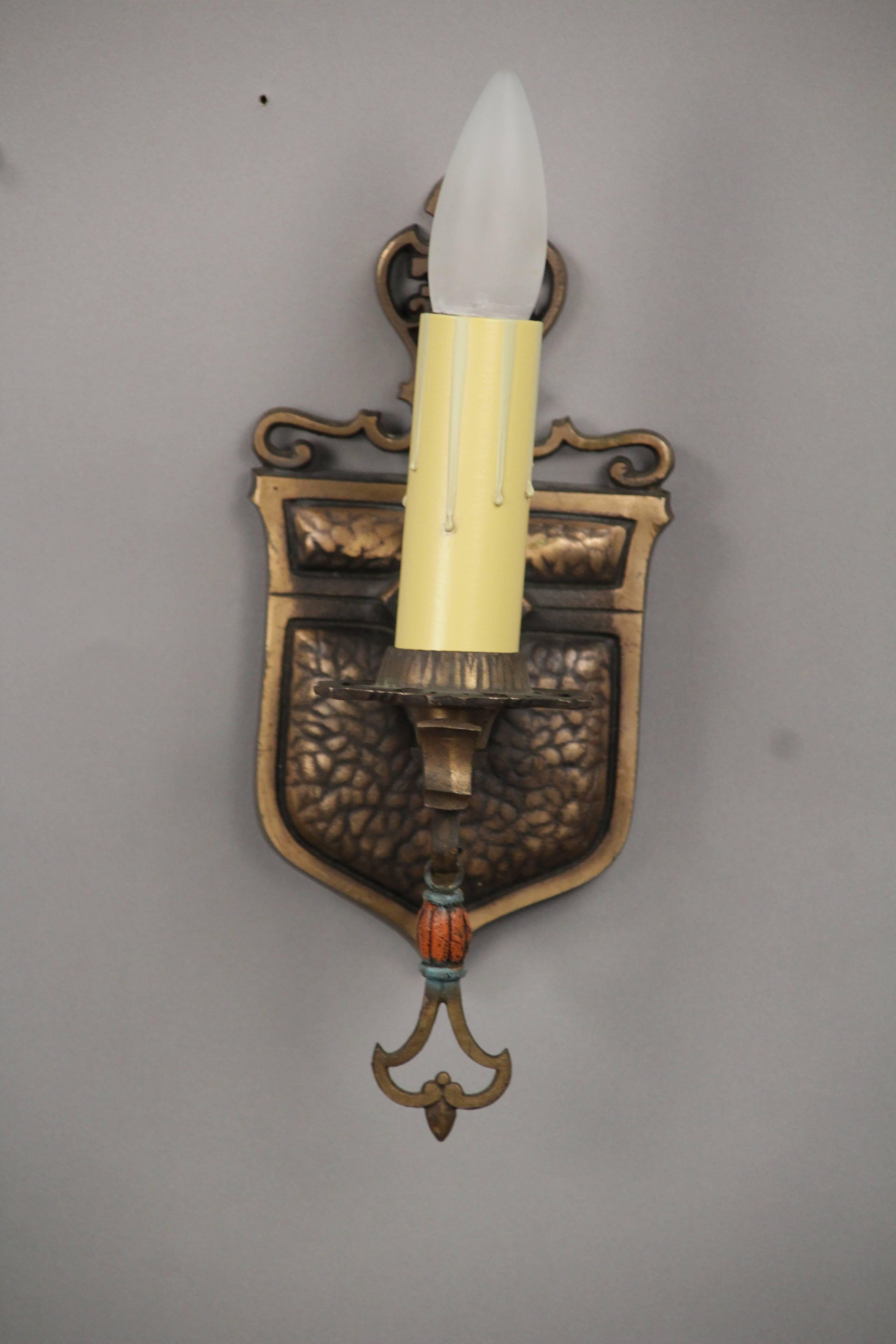 Sold and priced individually. 1 of 6 bronze sconce with shield motif.