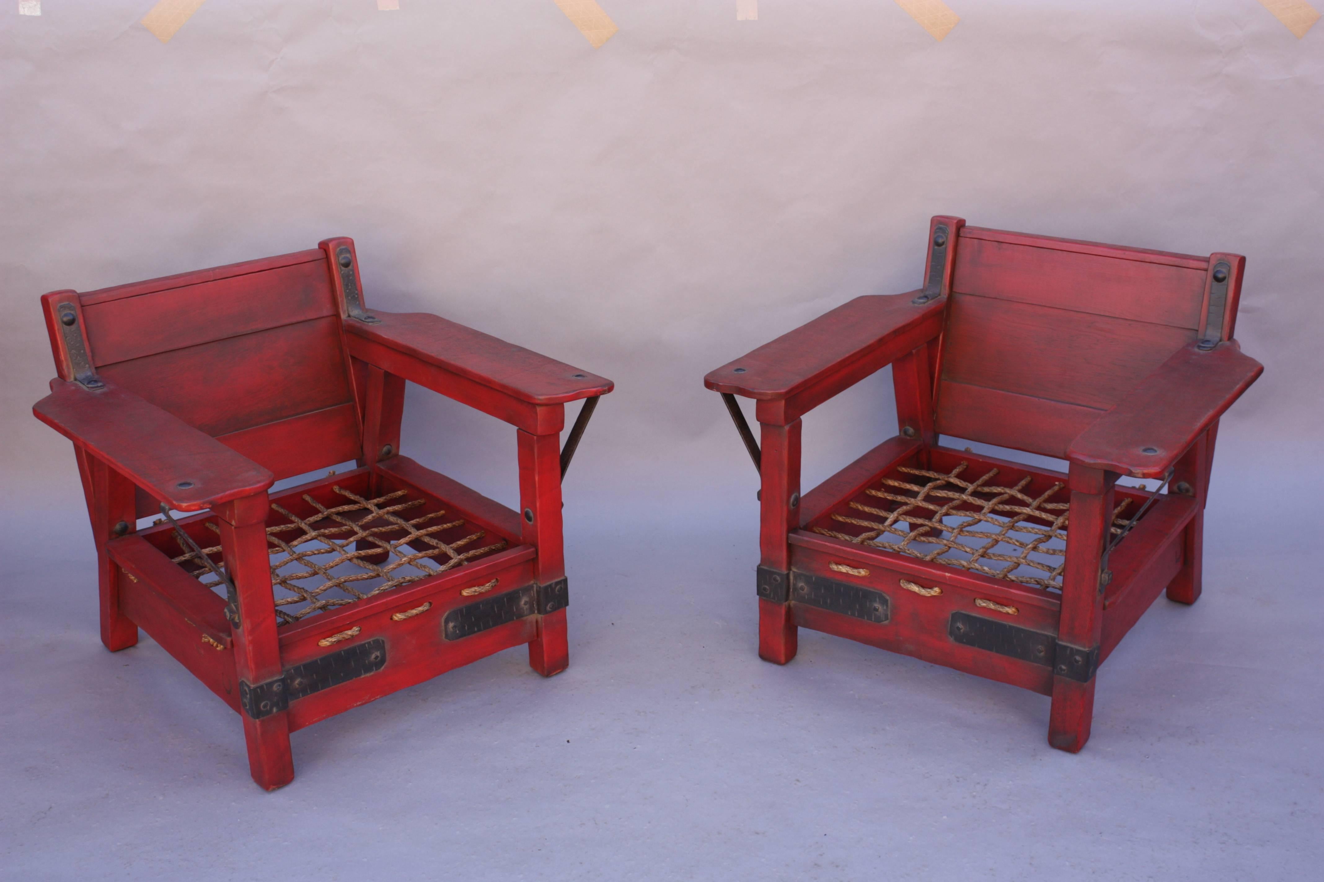 Early Classic monterey pair of rare red club chairs. The pair retains the original red color but some of the floral painting was professionally restored. Branded with the horseshoe mark. Measures: 30.25