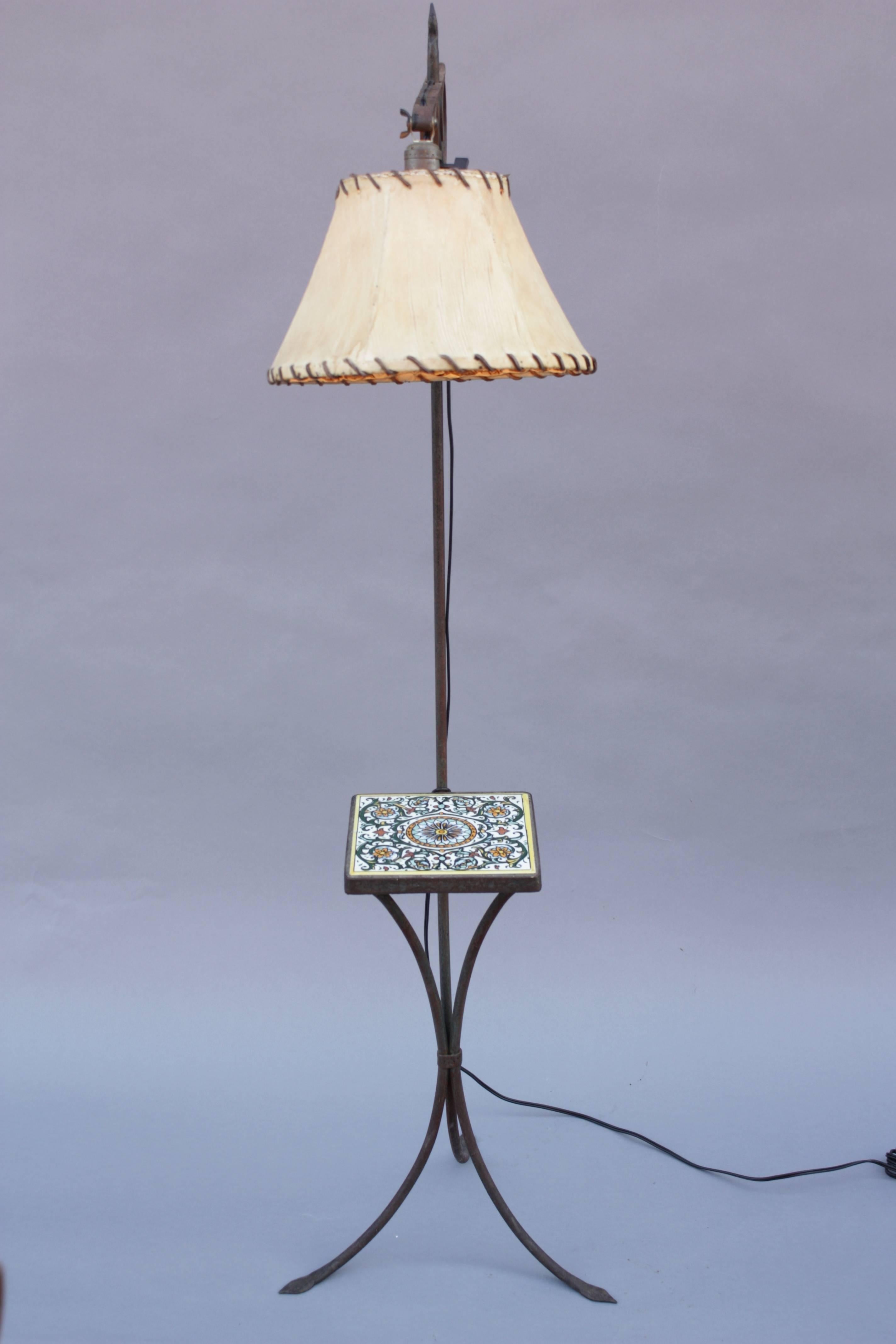 Great wrought iron floor lamp with vintage tile drink table. Rawhide shade. The height is adjustable.