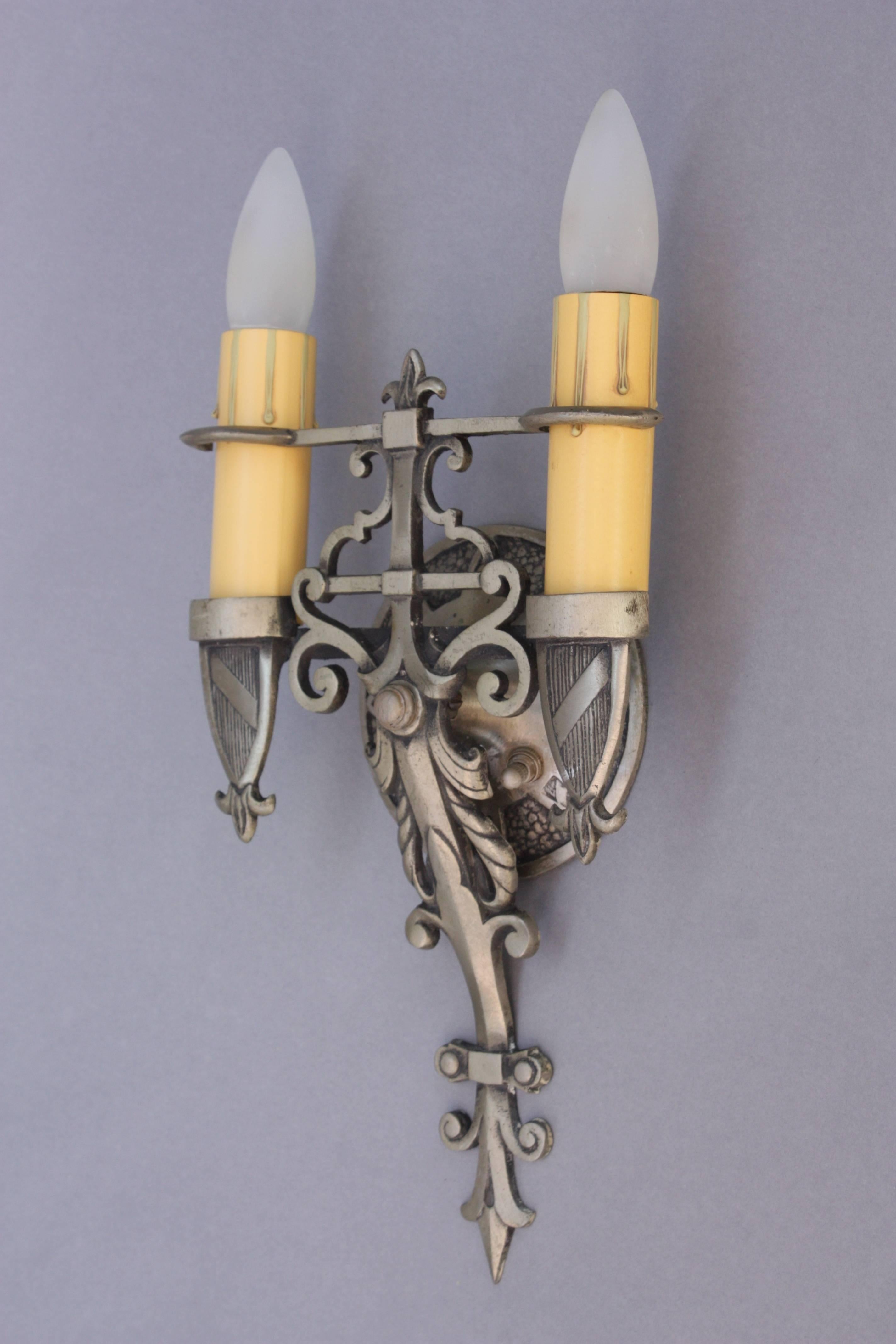 Ornately cast 1920s sconces with shield motif and pewter colored finish. Price is for the pair.
