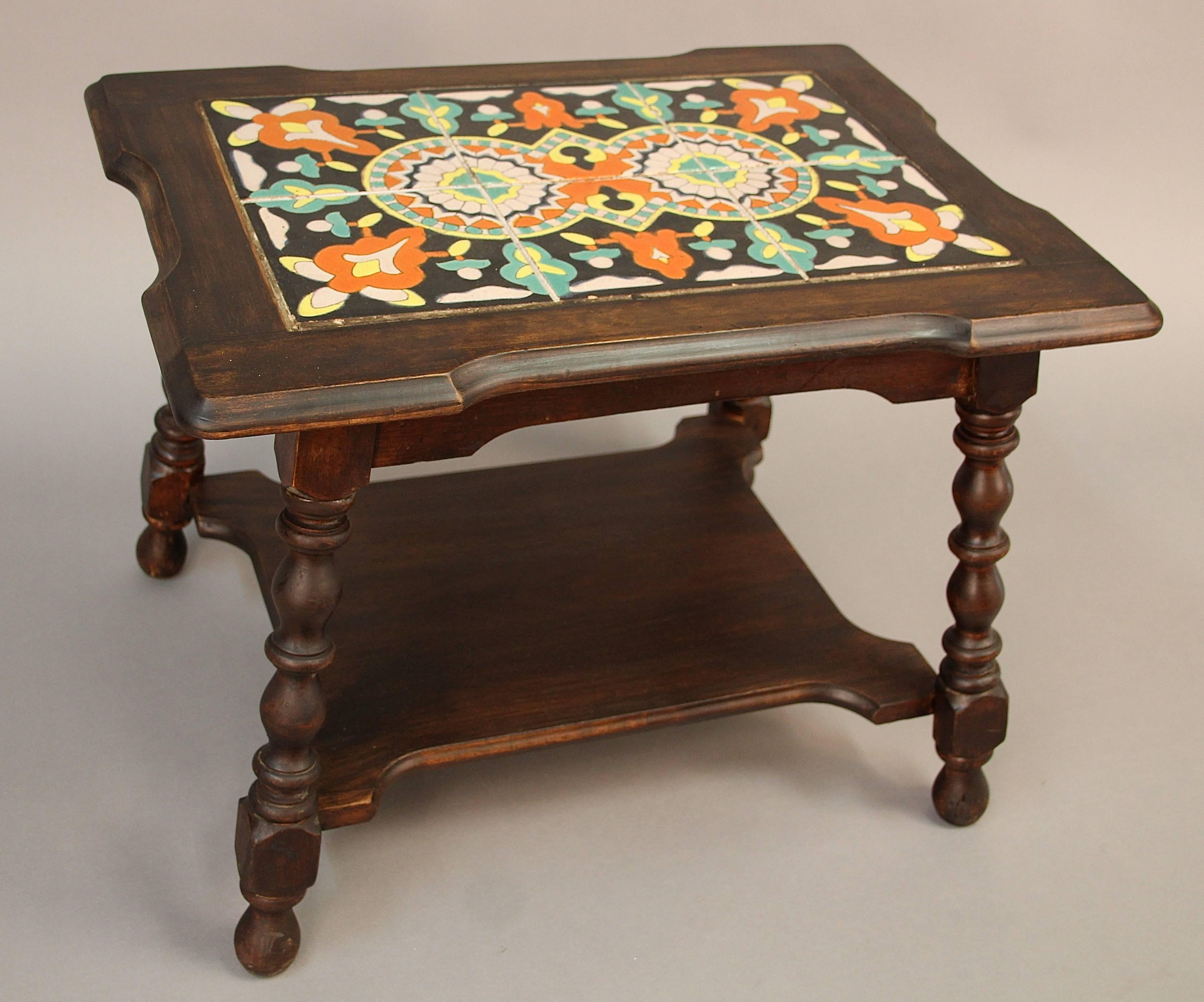 California tile table with turned legs and with additional display shelf on the bottom. Unusual shape with the cut-outs on the sides.