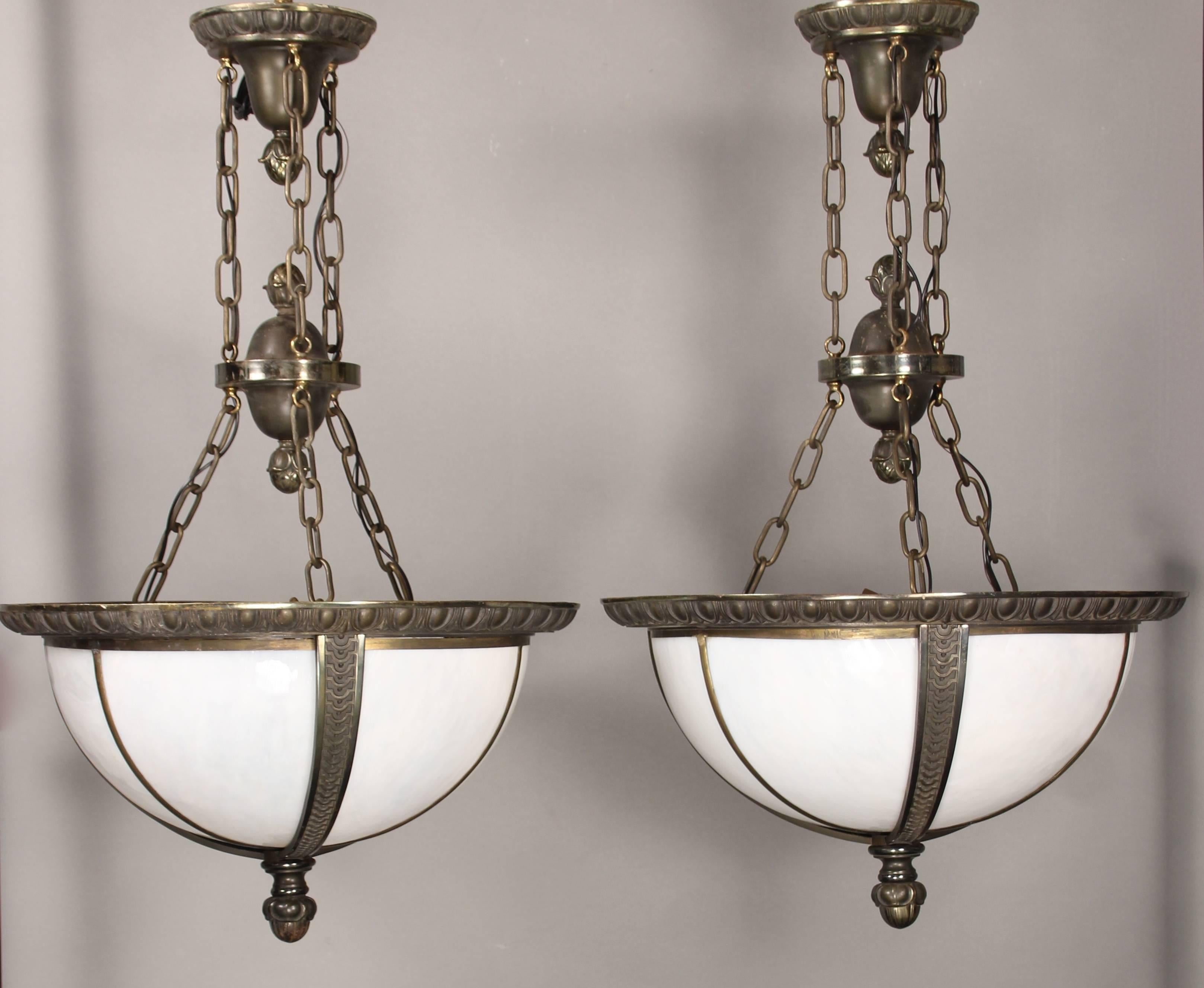 Priced and sold separately. Beautiful of 1920s pendant lights with original glass panels and crafted of finely cast bronze. Measures: 38