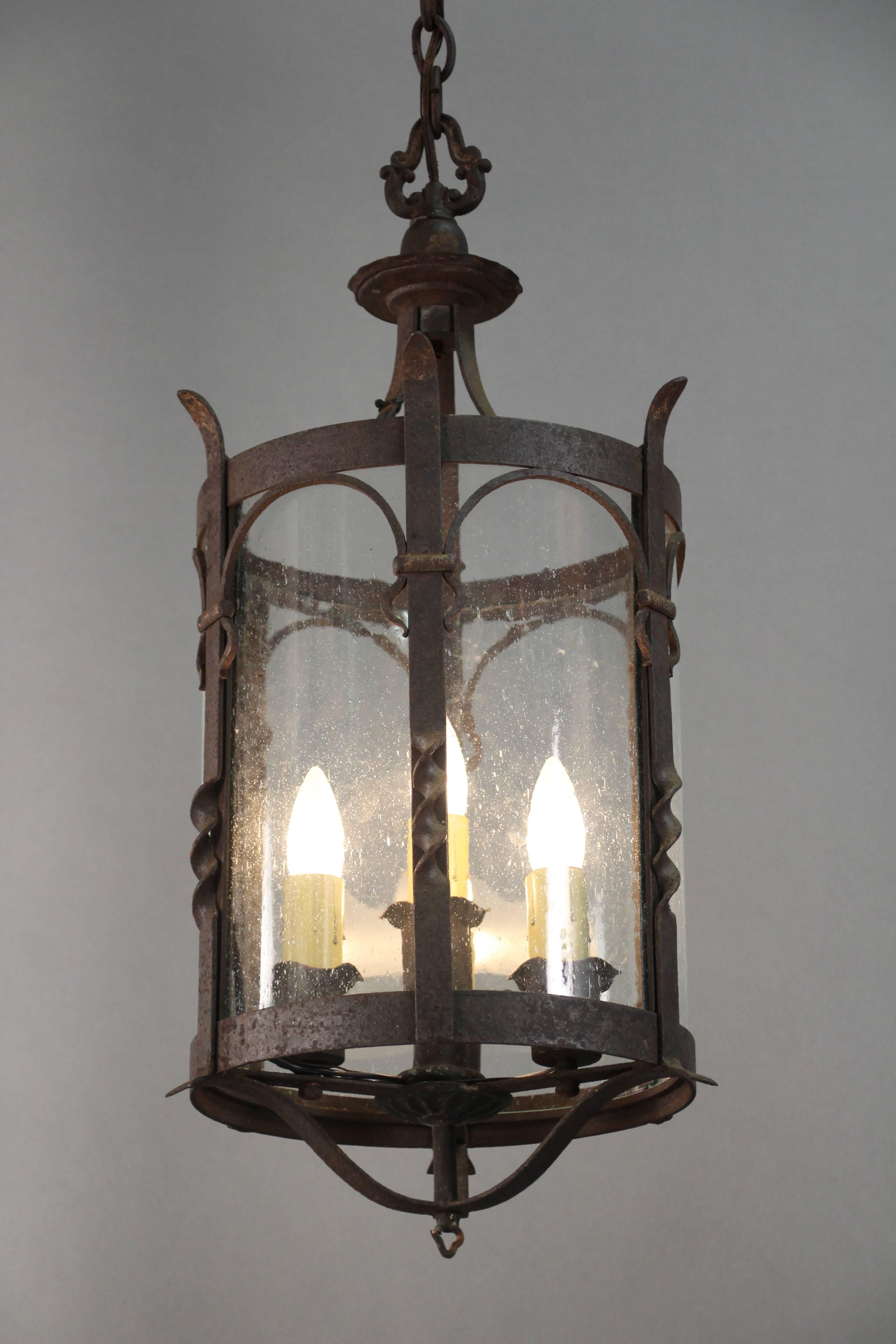Wrought iron pendant with glass with three lights. Original finish.
