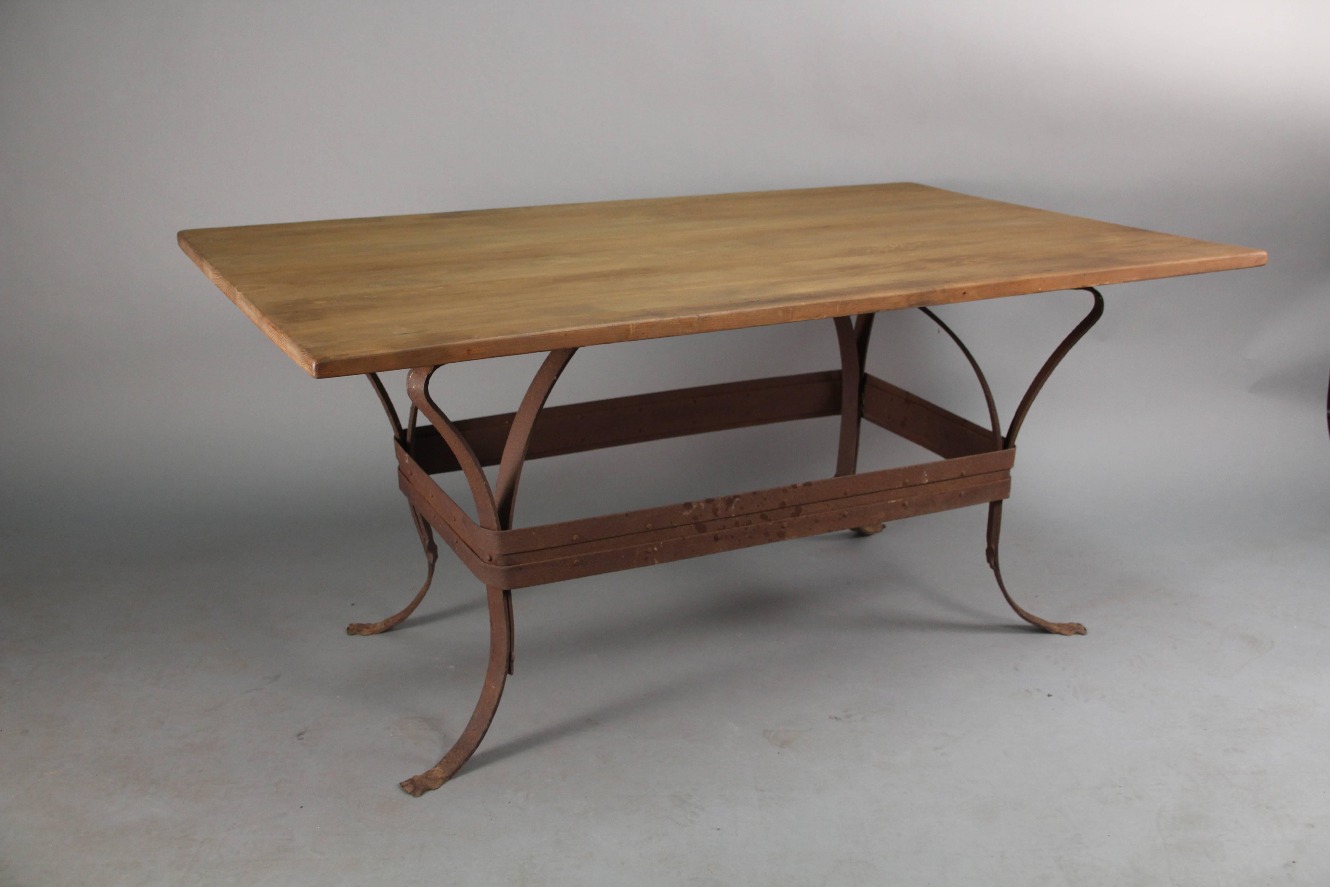 Rusty iron table base with great design and riveted construction. The top is a salvaged and worn.