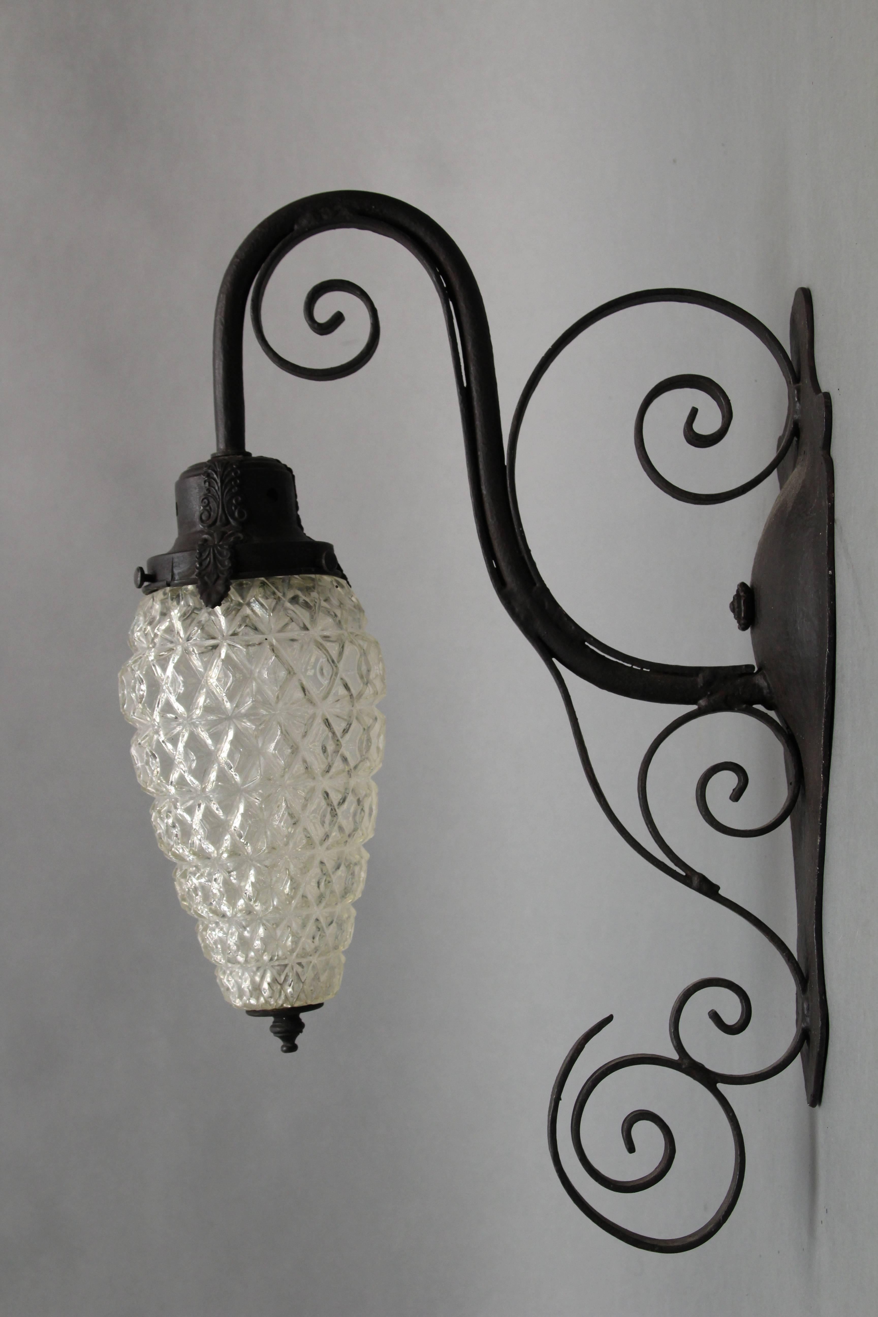 Elegant 1920s iron and glass light fixture with iron scrolls.