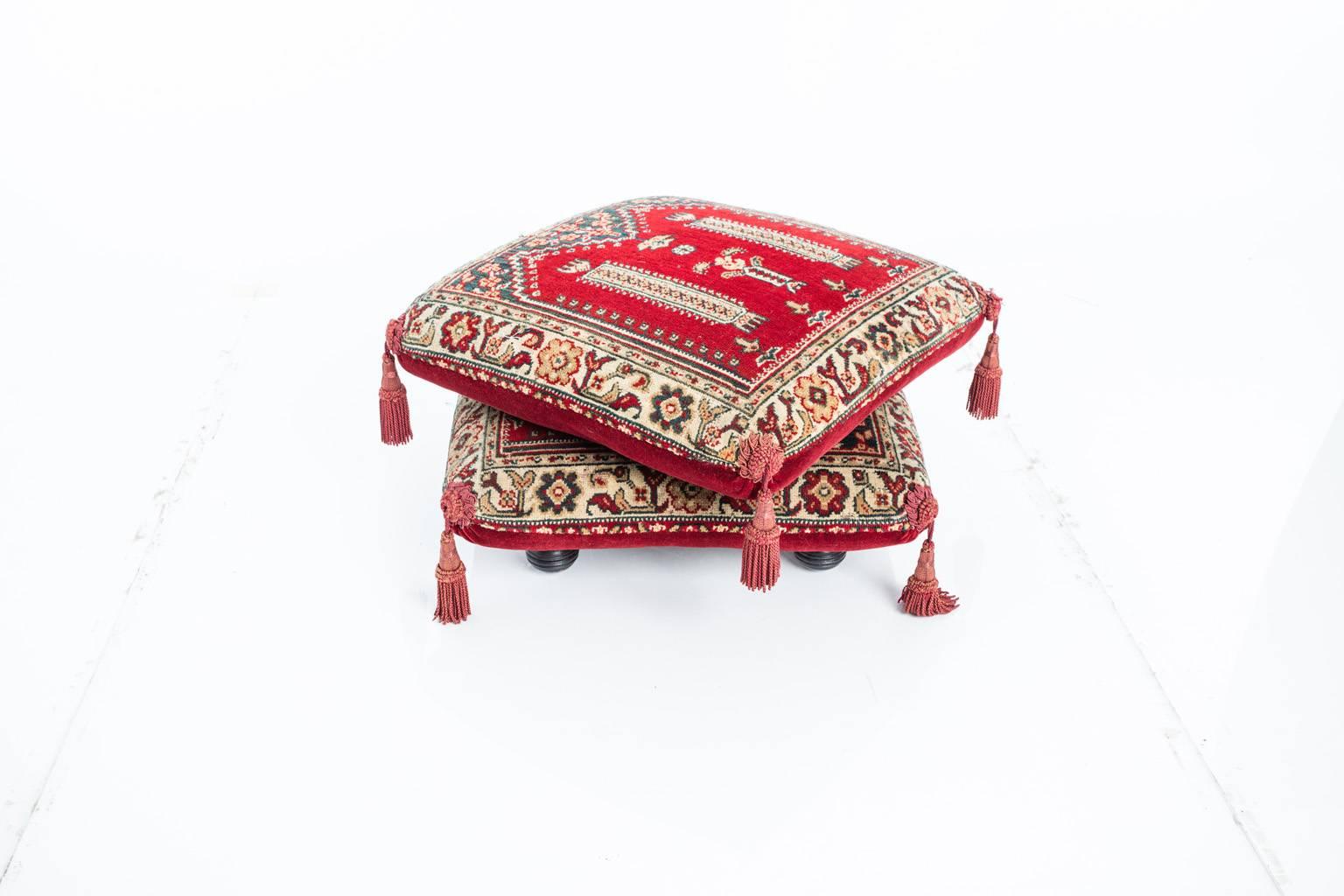 Vintage Turkish carpet puff. The ottoman is composed of two pillows decorated with tassels resting on wooden base. Both pillows are permanently attached to the base. Pillows are covered with velvet, and upholstered in a handwoven carpet.