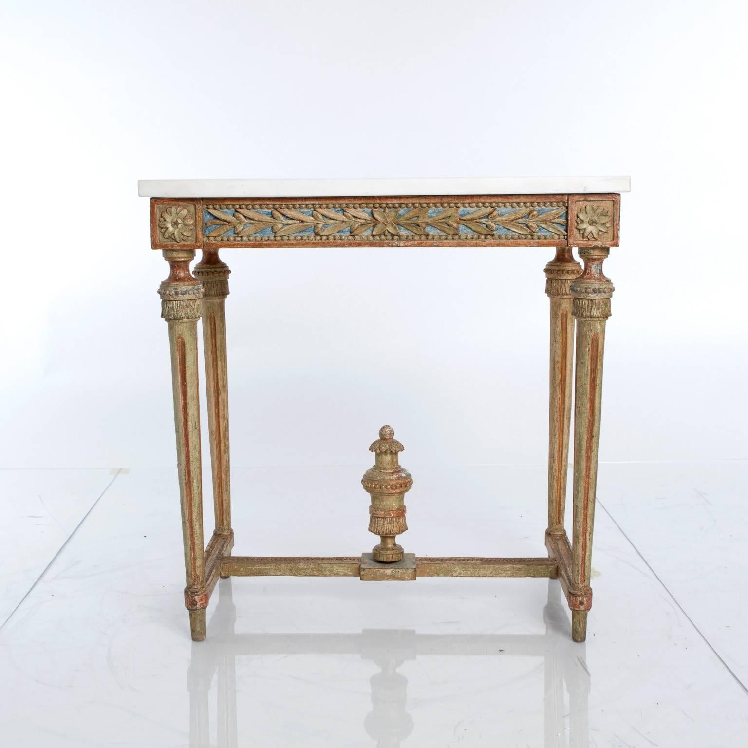 Swedish, late 18th century. A giltwood Gustavian console table with a white marble top. Carved foliage frieze on four sides. Carved rosettes. Round fluted legs. Cross stretcher with carved urn-shaped finial.
  