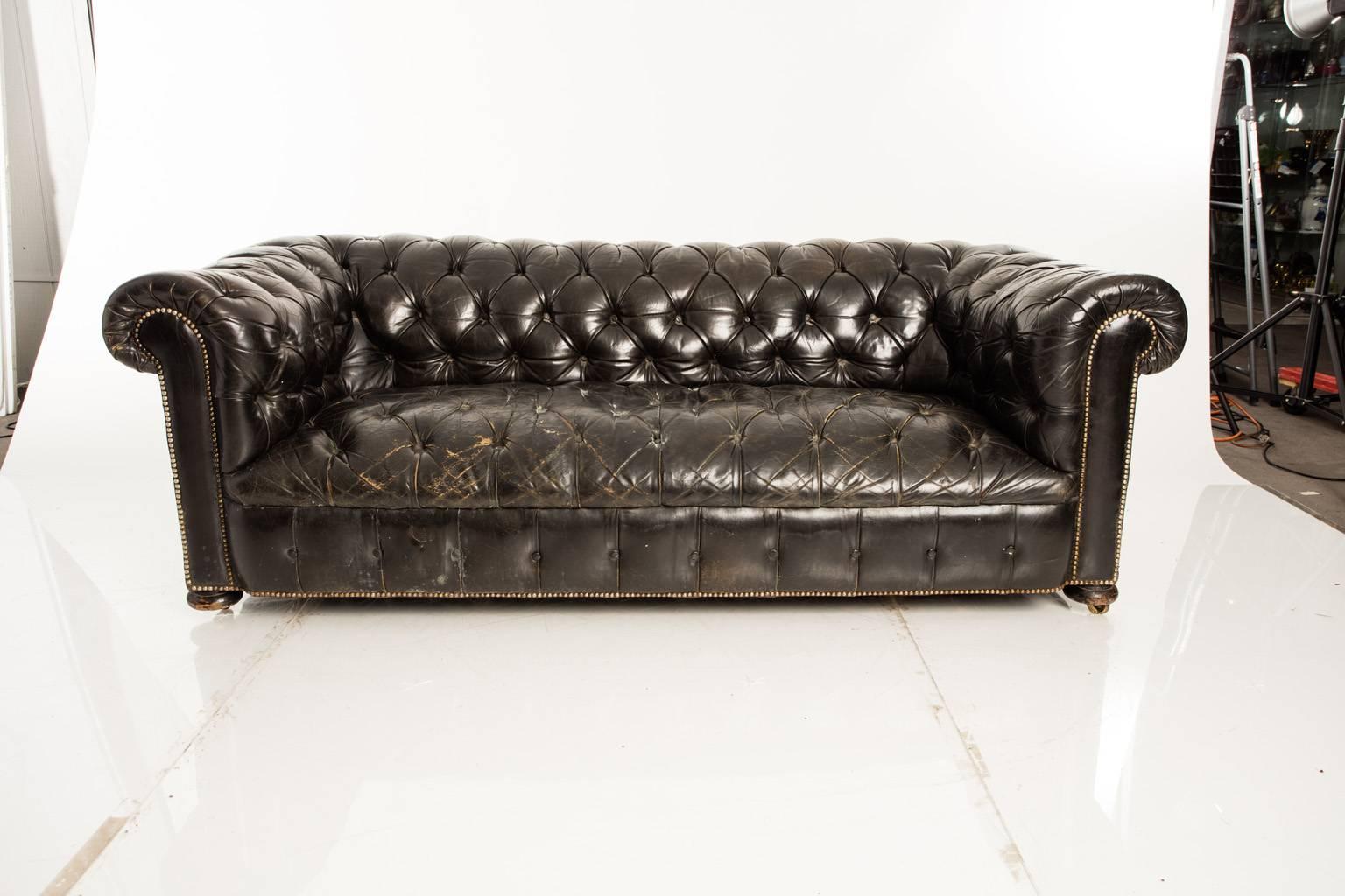 English chesterfield sofa. Distressed leather. On casters.