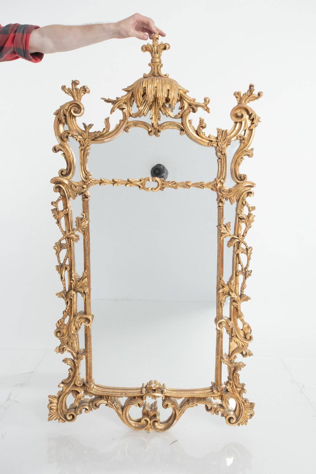 Wonderfully ornate French, gesso and gilt mirror with intricate volute details.