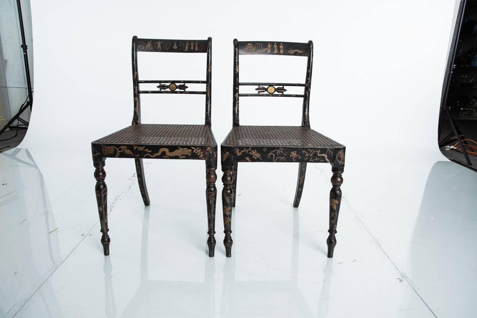 19th century pair of beautifully decorated Regency style side chairs with cane seats.