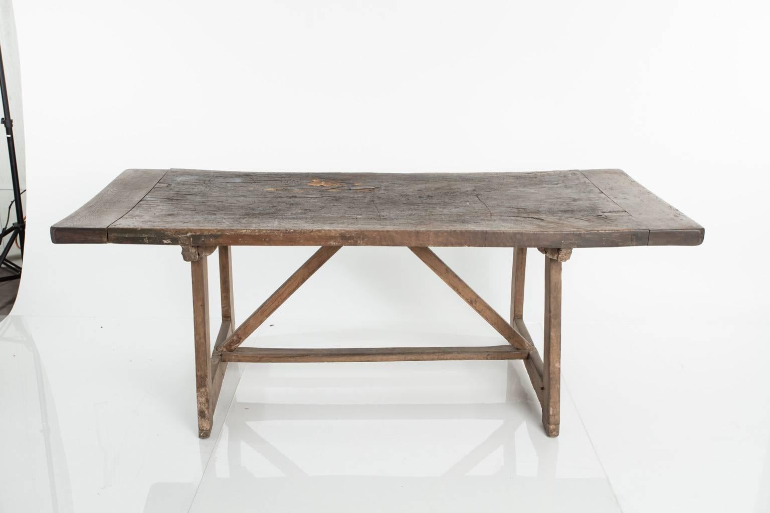 Italian walnut, single board work table. Trestle base with a breadboard top.