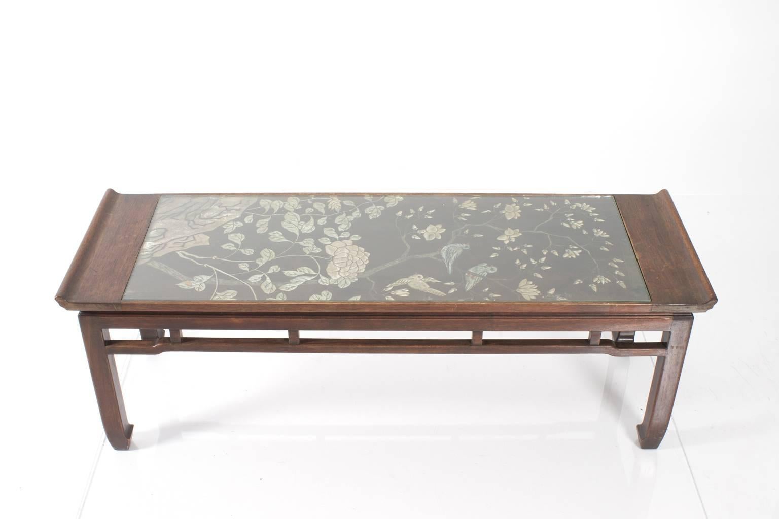 Chinese style coffee table decorated with a pale blue screen inset.
 