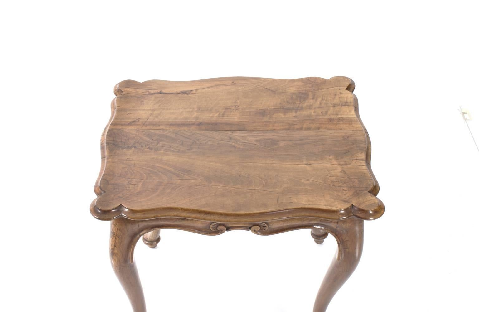 Walnut side table with cabriole legs, scalloped edges and a shell motif throughout.
 