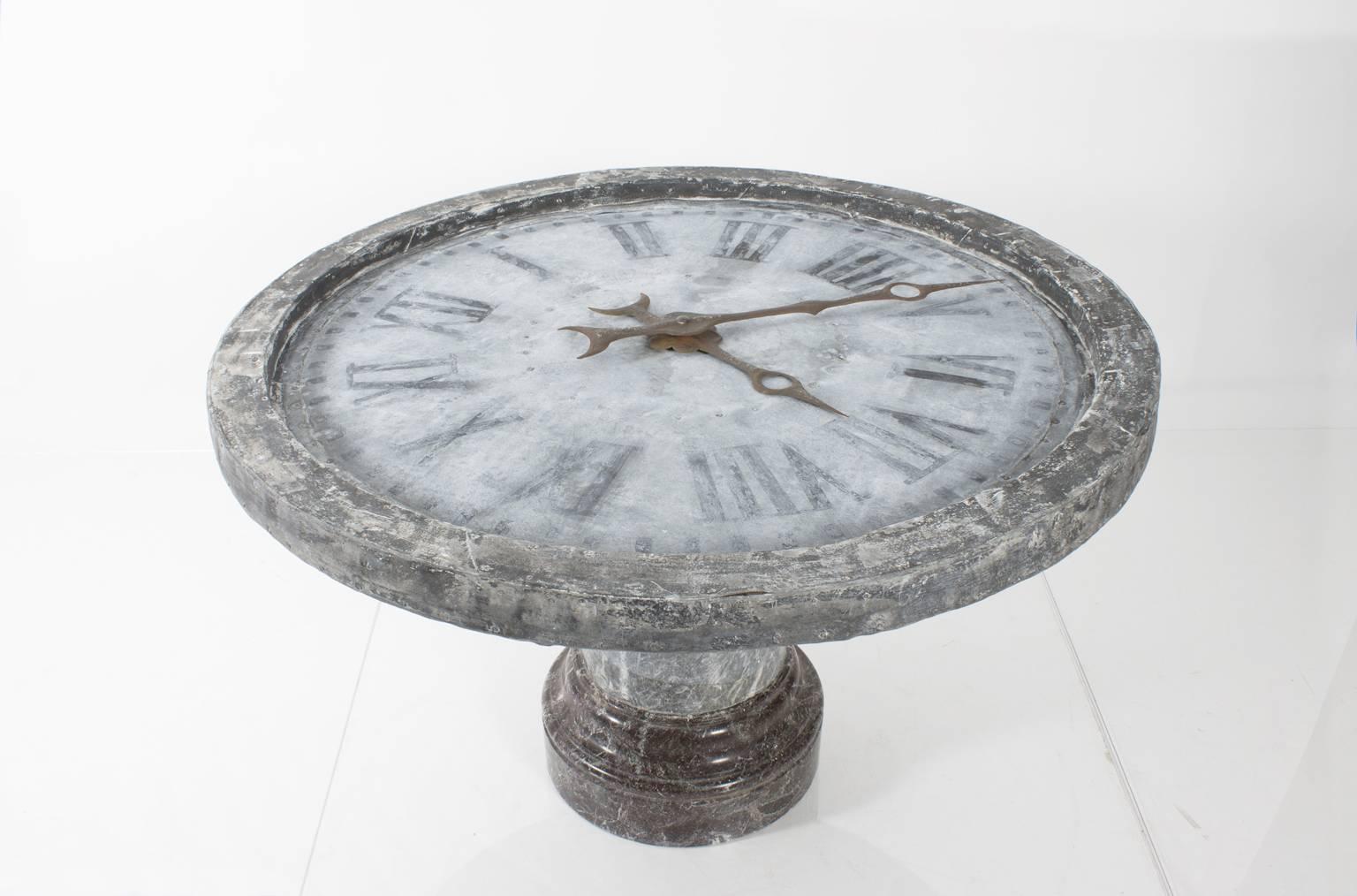 Glass topped clockface table. Zinc and marble make up the base of this unusual piece.
 