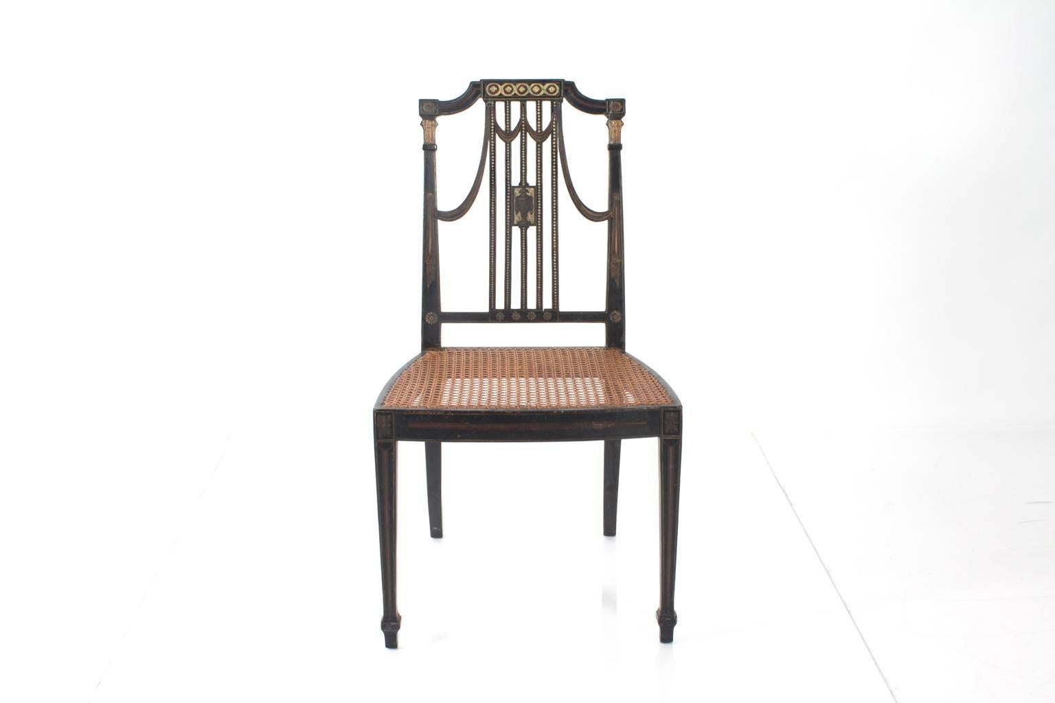 Pair of 19th century, Adams style chairs with caned seats. Ebonized with gilt Grecian designs.