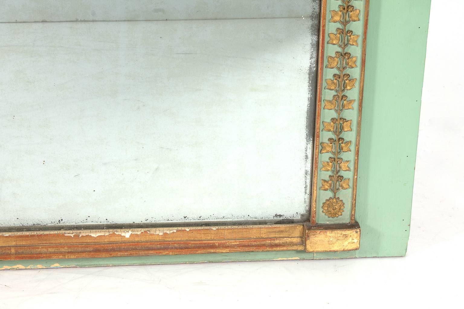 Late 19th century green painted and partially gilded Louis XVI mirror with carved garland applique.