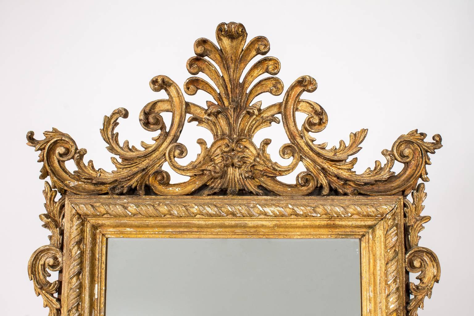 Large decorative mirror in a heavily craved frame.