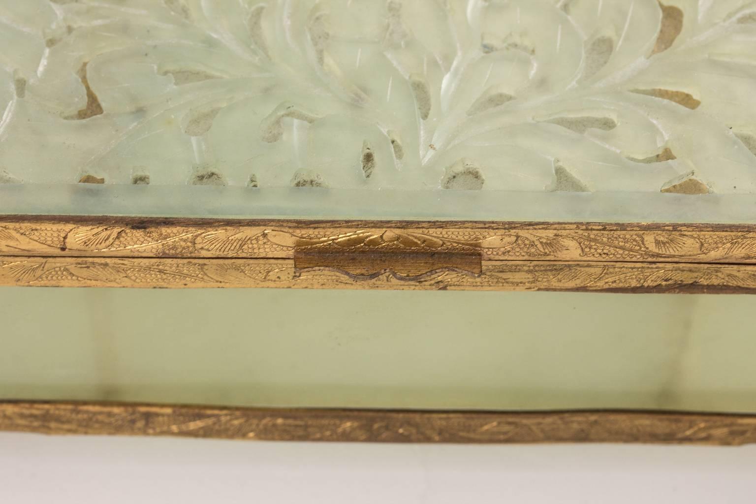 Intricately carved jade box with hinged lid and brass mounts.