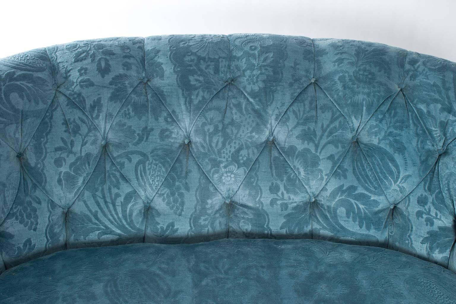 1940s style curved Hollywood Regency sofa attributed to Syrie Maugham. Beautifully upholstered in blue cut velvet with decorative fringe.